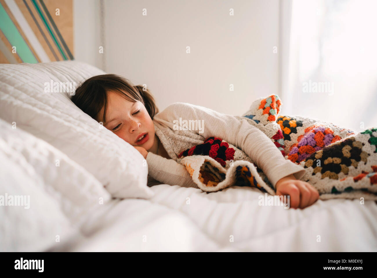 Ragazza che si stendeva a letto con un pisolino pomeridiano Foto Stock