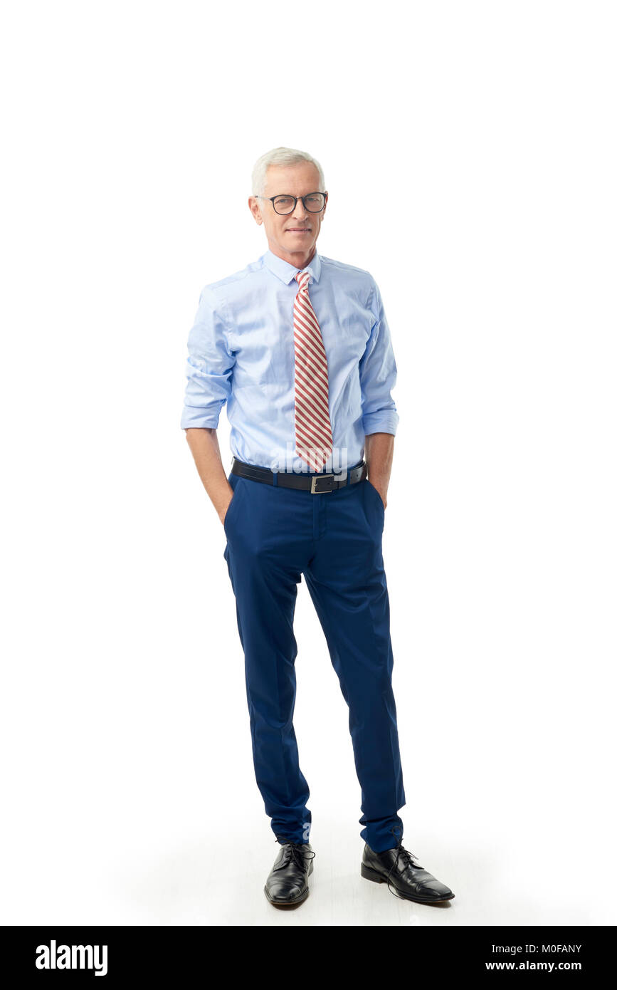 A piena lunghezza shot di un imprenditore senior in piedi con arrotolato a maniche camicia e cravatta isolato a sfondo bianco. Foto Stock