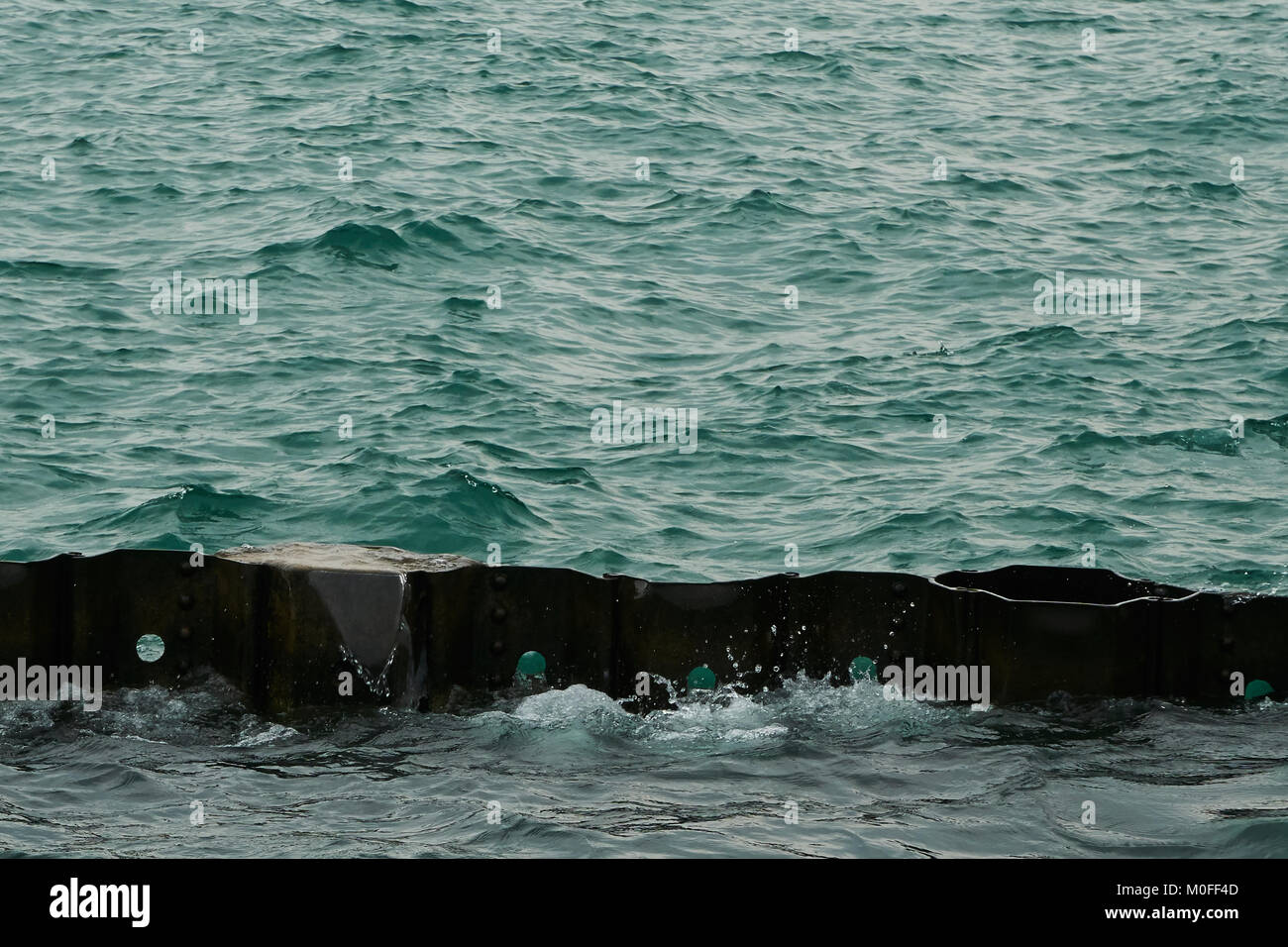 Blu Verde acqua colpendo frangionde lungo il fronte lago di Chicago Foto Stock