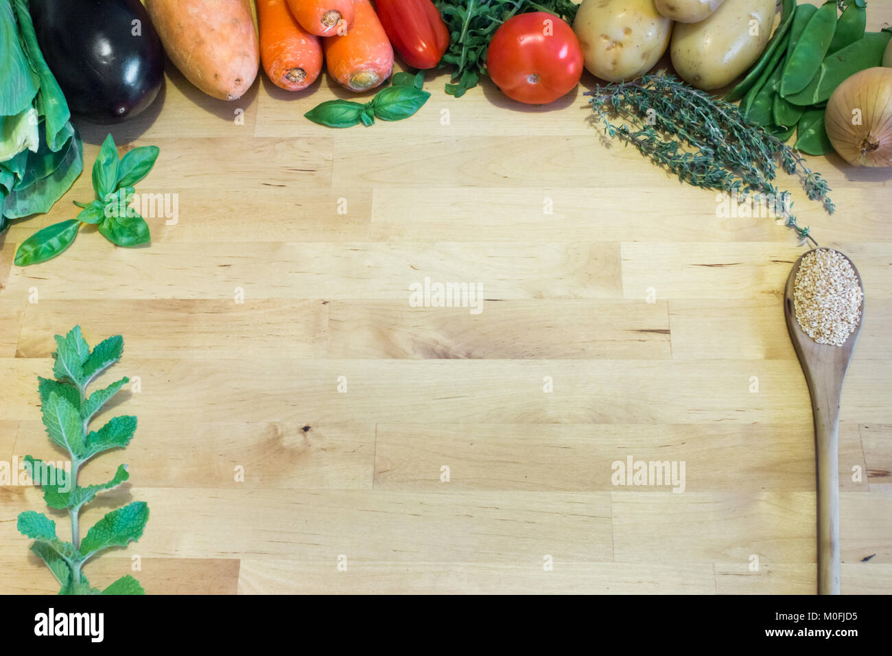 Cibo sano concetto con verdure, erbe e cucchiaio su sfondo di legno. Spazio vuoto per il testo, il design e il decor. Vegano sano / dieta vegetariana Foto Stock