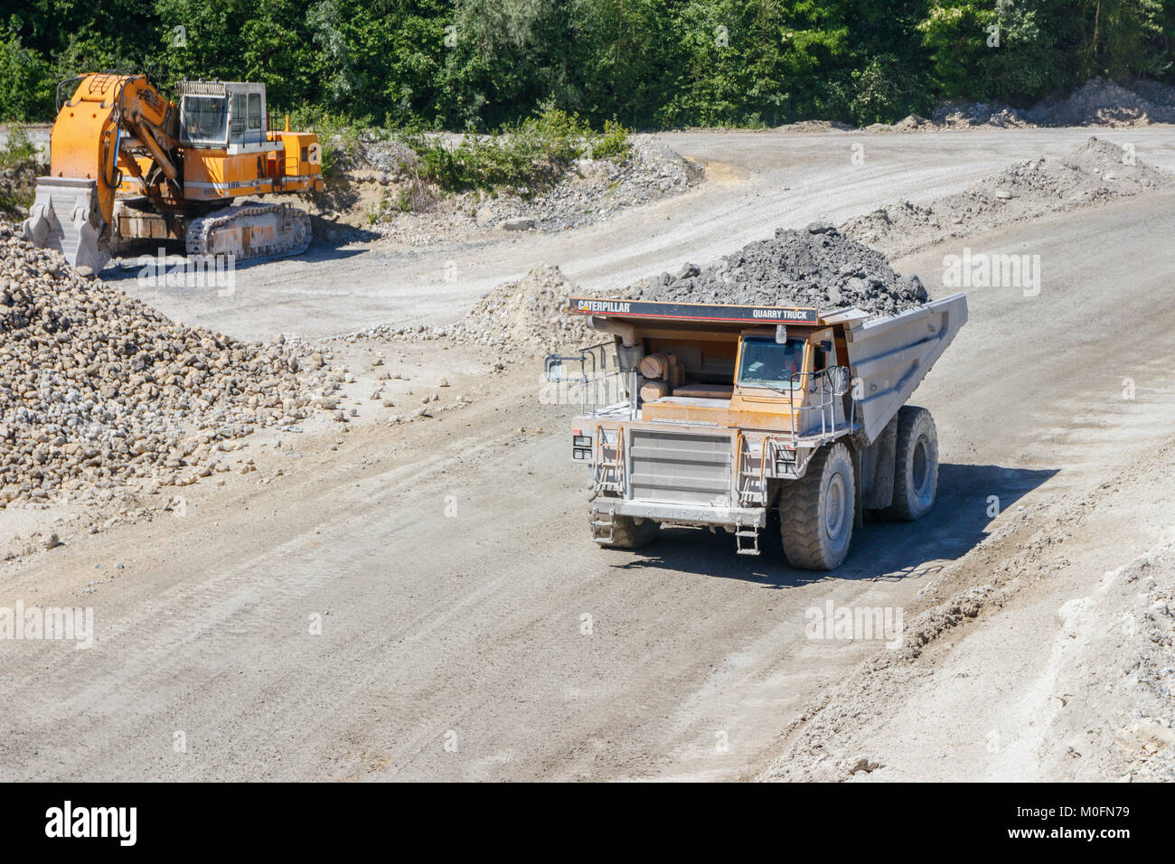 Escavatore cingolato e camion guida con un carico di Marl all'ENCI (primo olandese industria del cemento) cava di marna, Maastricht, Paesi Bassi. Foto Stock