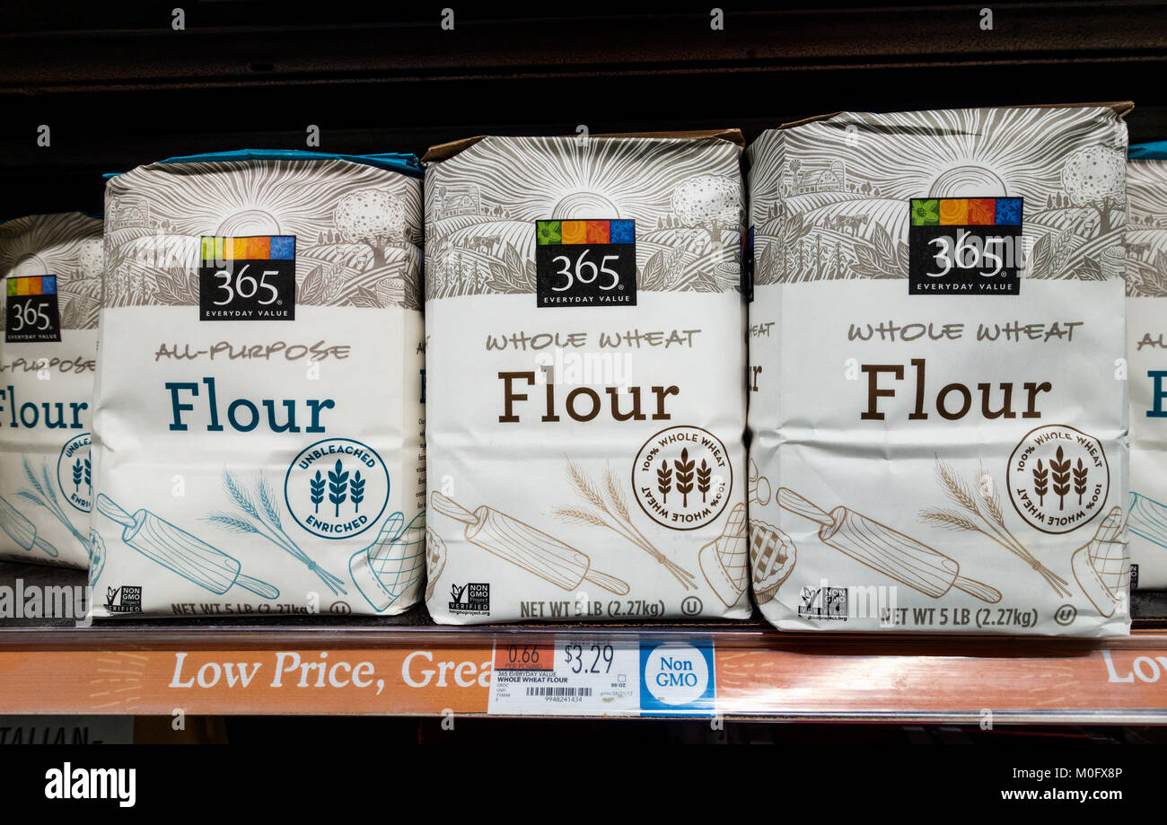 Sacchetti di bianco e tutta la farina di grano su un ripiano a Whole Foods Market Foto Stock