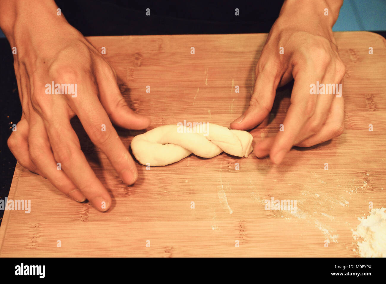 Uomo raw per impastare la pasta a ciambella Foto Stock