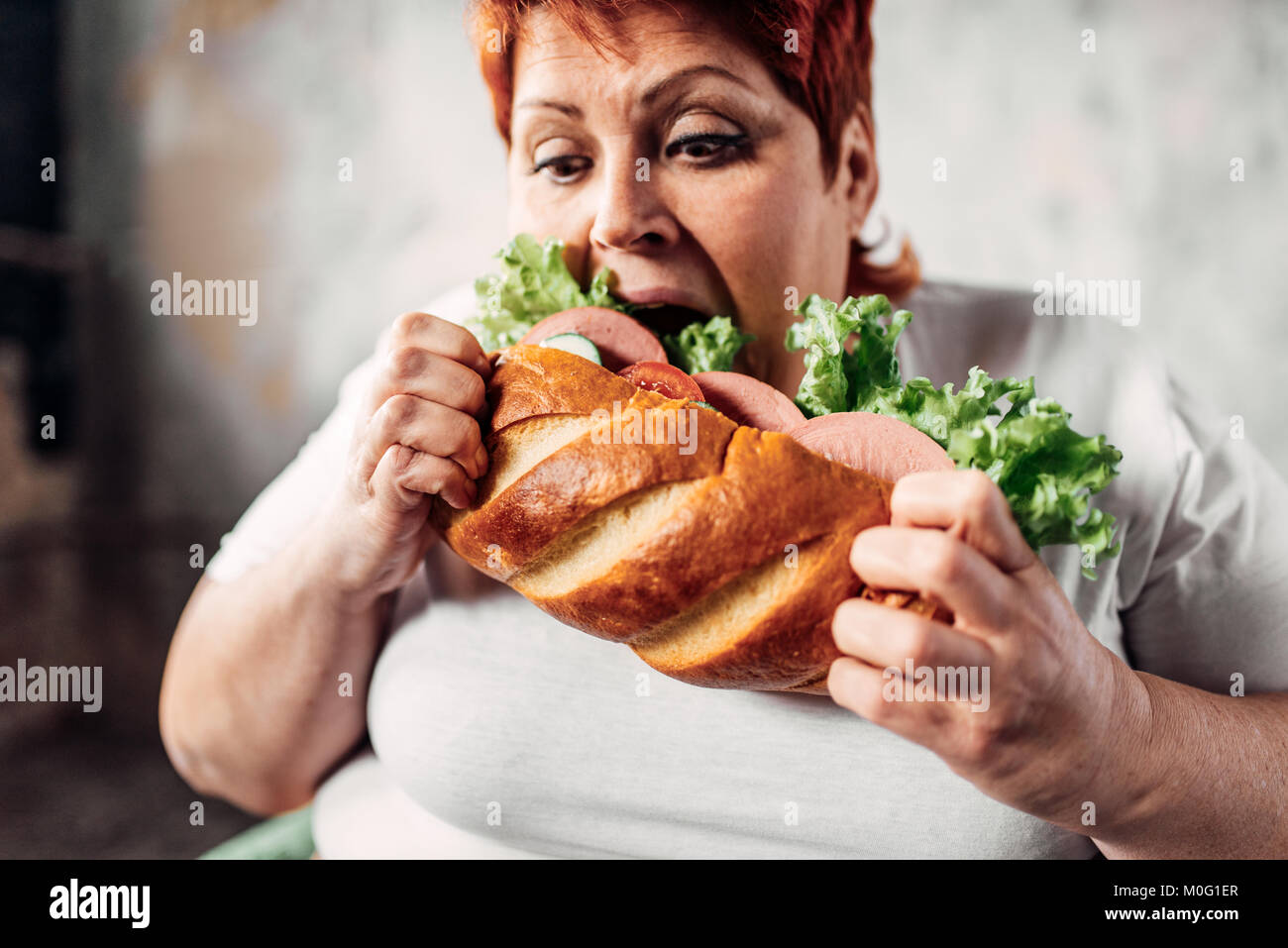 Grasso donna mangia sandwich, sovrappeso e bulimic. Uno stile di vita poco salutare, obesità Foto Stock