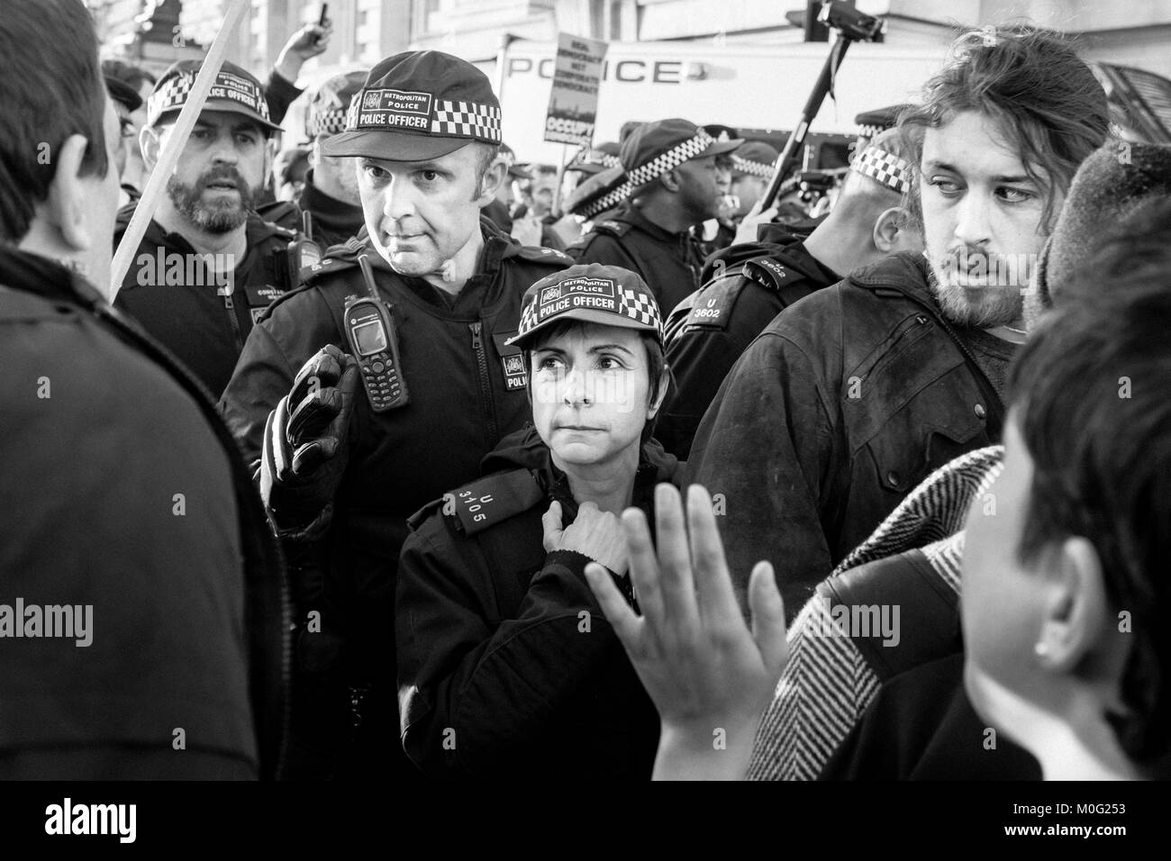 Fotografia di strada in bianco e nero a Londra: Gli ufficiali della polizia metropolitana si confrontano con i manifestanti durante la marcia di protesta nel centro di Londra. Foto Stock