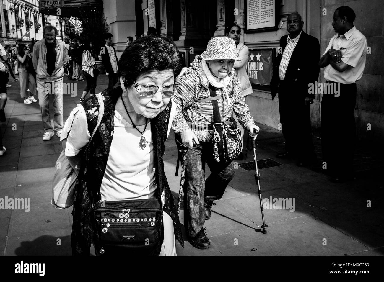 Fotografia di strada bianca e nera a Londra: Due donne anziane camminano attraverso il centro di Londra. Foto Stock