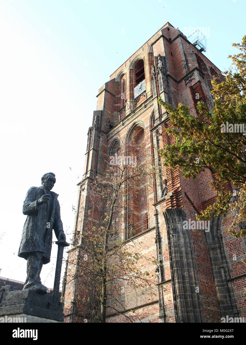 Il famoso Oldehove pendente Torre della chiesa in Leeuwarden, Friesland, Paesi Bassi con una statua di Frisone politico Pieter Jelles Troelstra Foto Stock