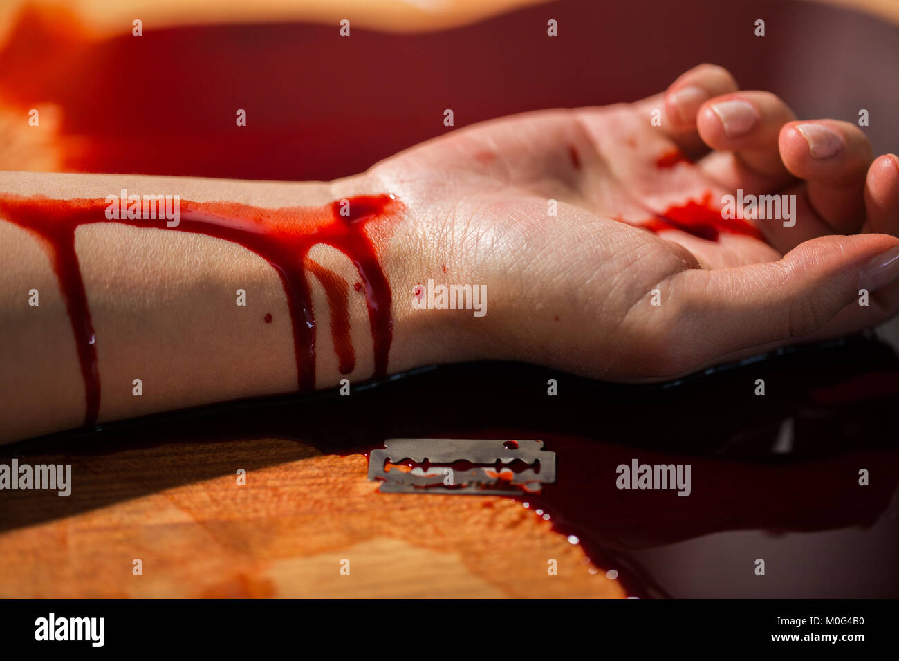 Donna morta la mano nel sangue sul pavimento in corrispondenza della scena del crimine Foto Stock