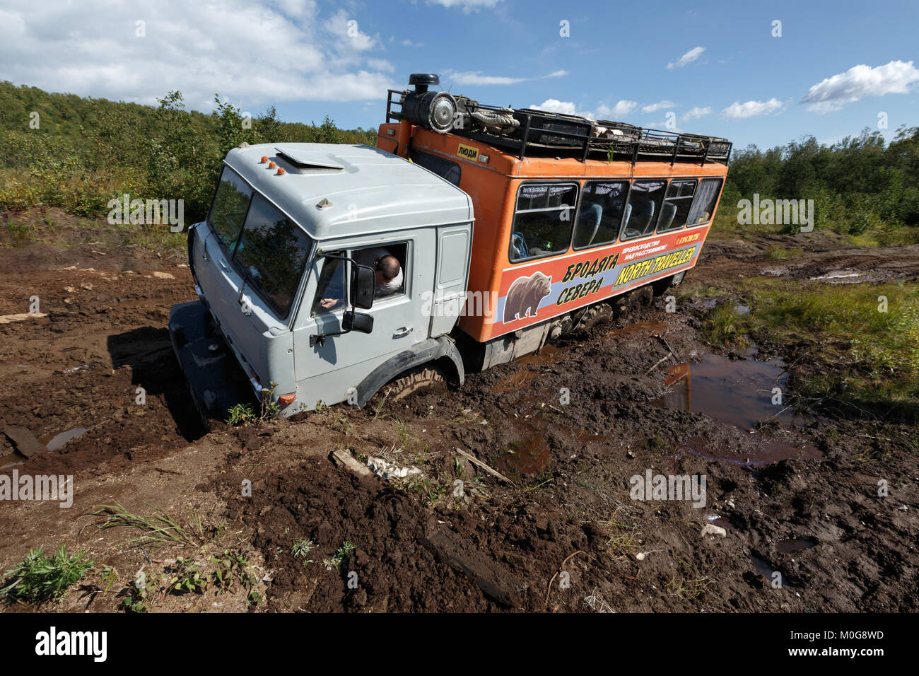 Il russo off-road extreme spedizione carrello KamAZ (sei ruote motrici) per il trasporto di turisti e viaggiatori, bloccata nel profondo della foresta fangoso road. Foto Stock