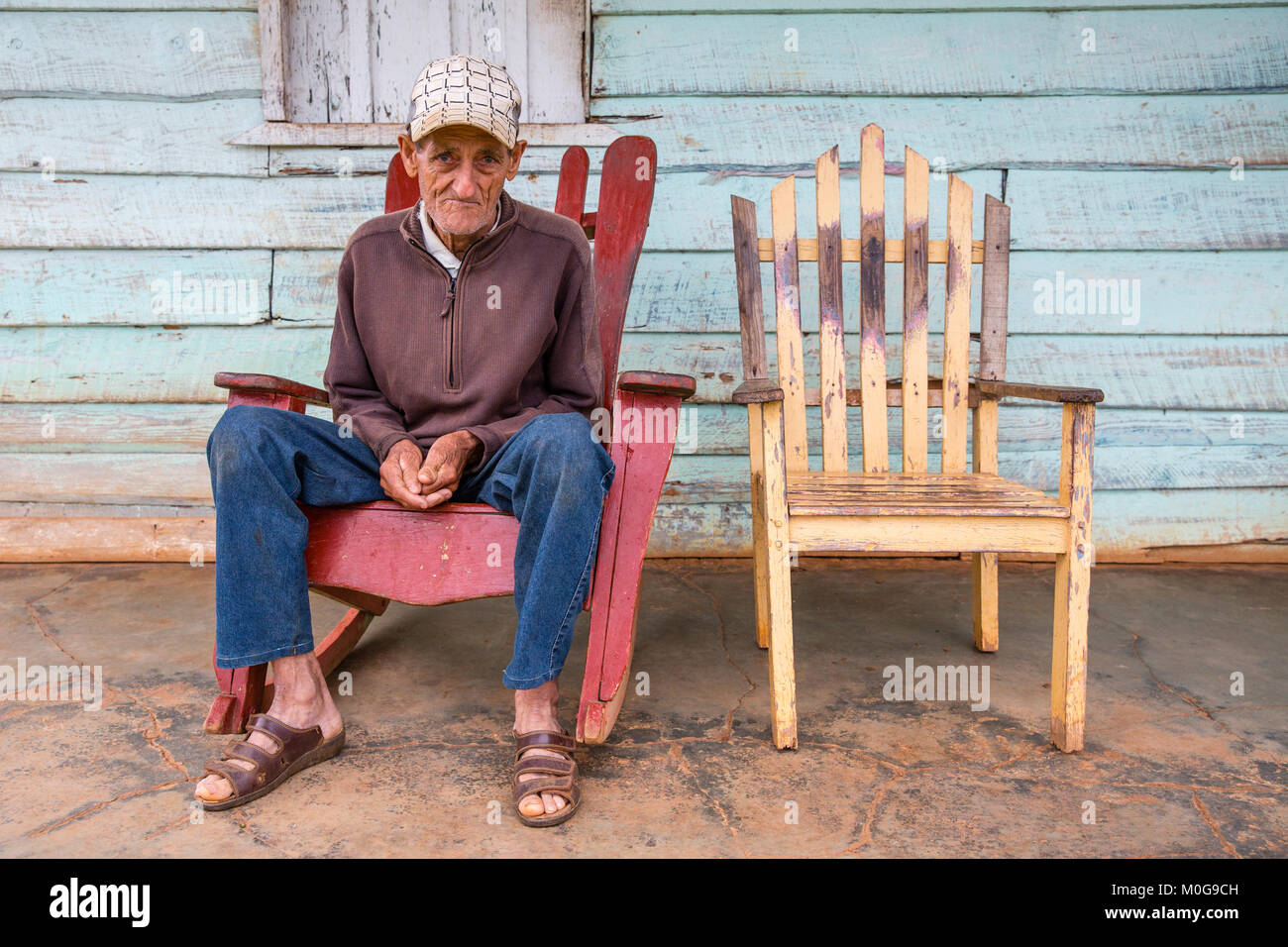 Lonely Man in sedia a dondolo sulla veranda, Vinales Valley, Cuba Foto Stock