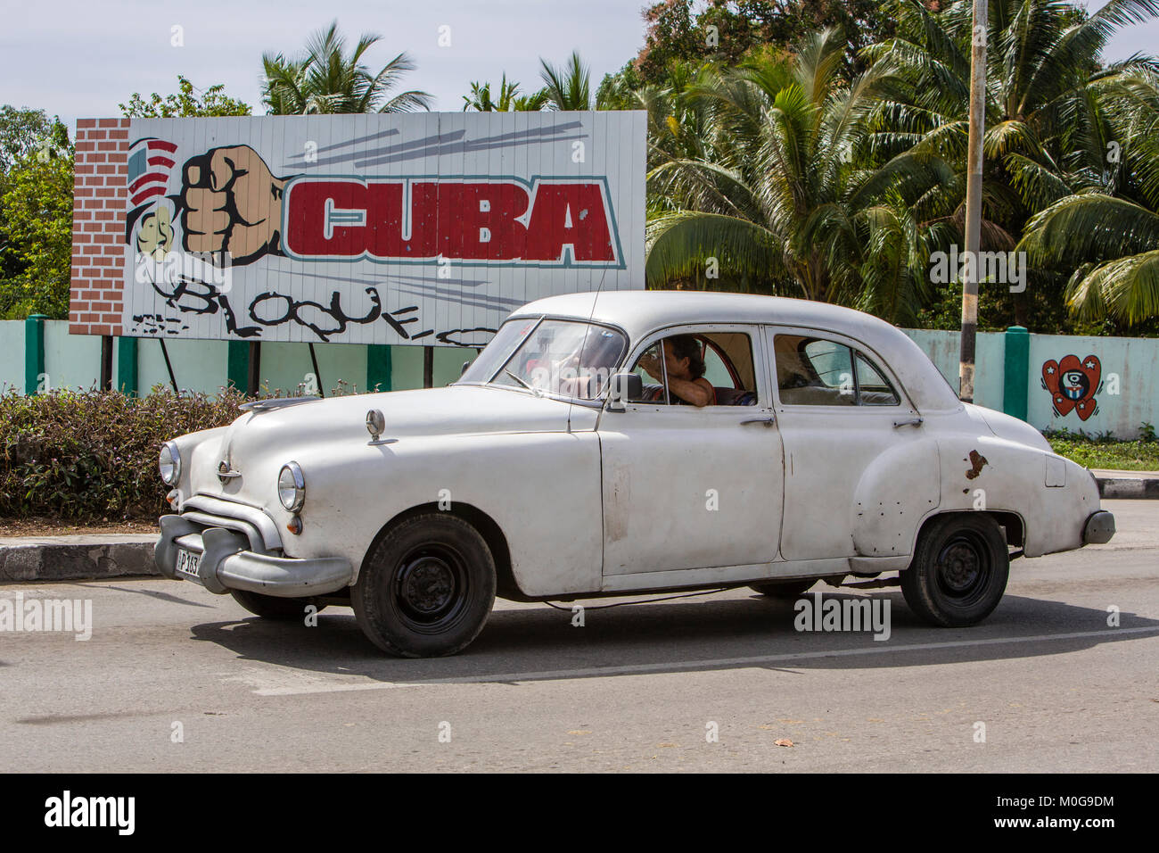 Classic American car guida passato lo zio Sam segno, Rio Guanayara, Cuba Foto Stock