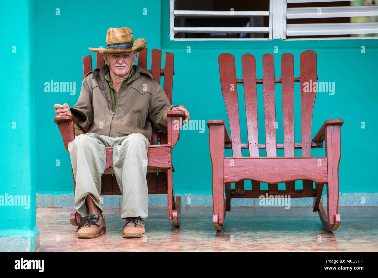 Lonely Man in sedia a dondolo sulla veranda, Vinales Valley, Cuba Foto Stock