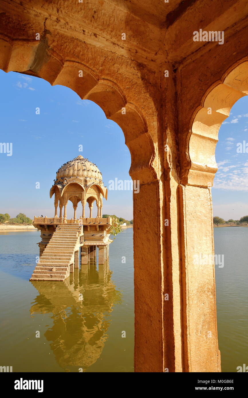 Vista di un chhatri (attraverso archi) a Gadi Sagar lago, Jaisalmer, Rajasthan, India Foto Stock