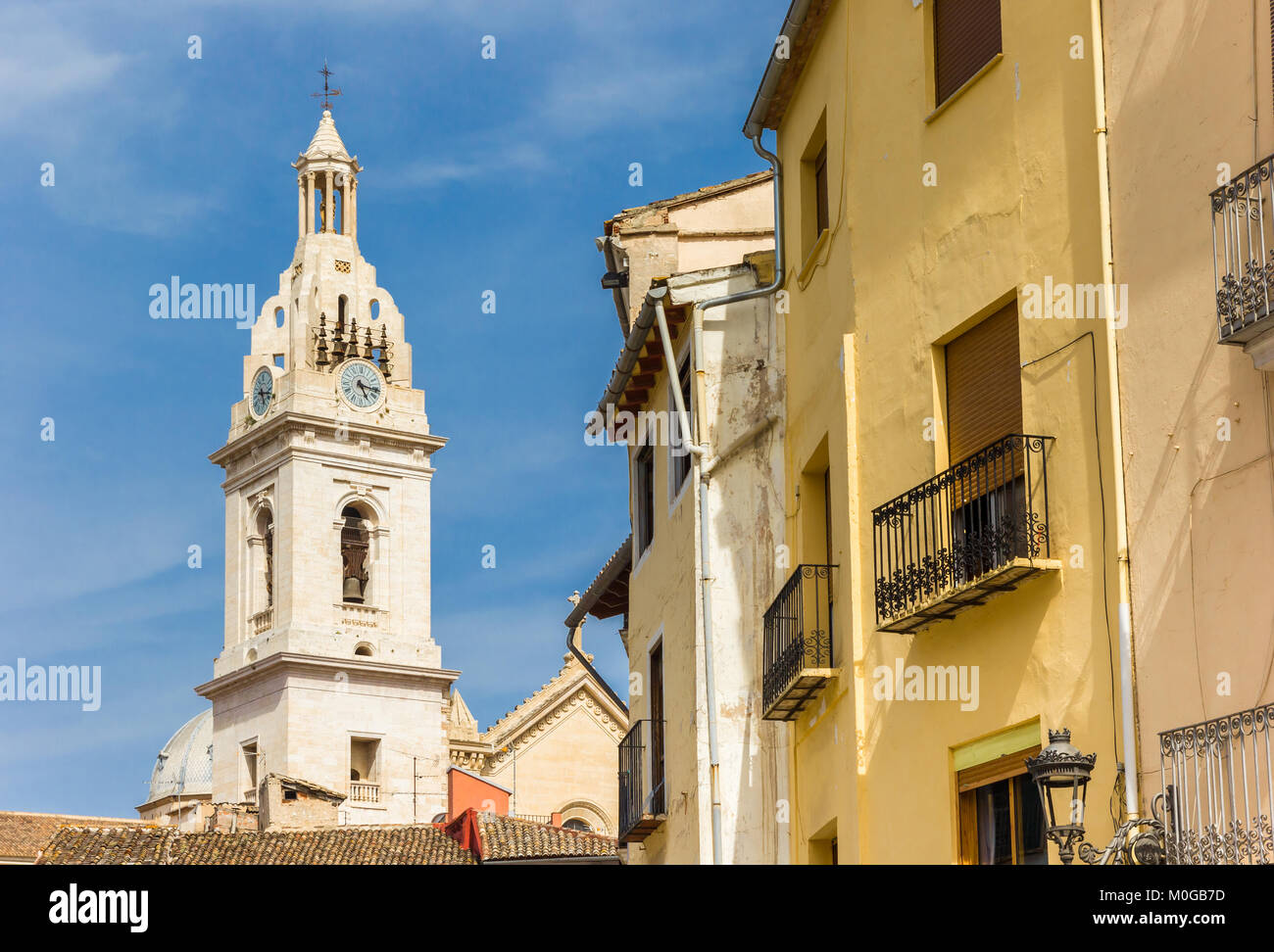 La torre della chiesa di Santa Maria e case colorate a Xativa, Spagna Foto Stock