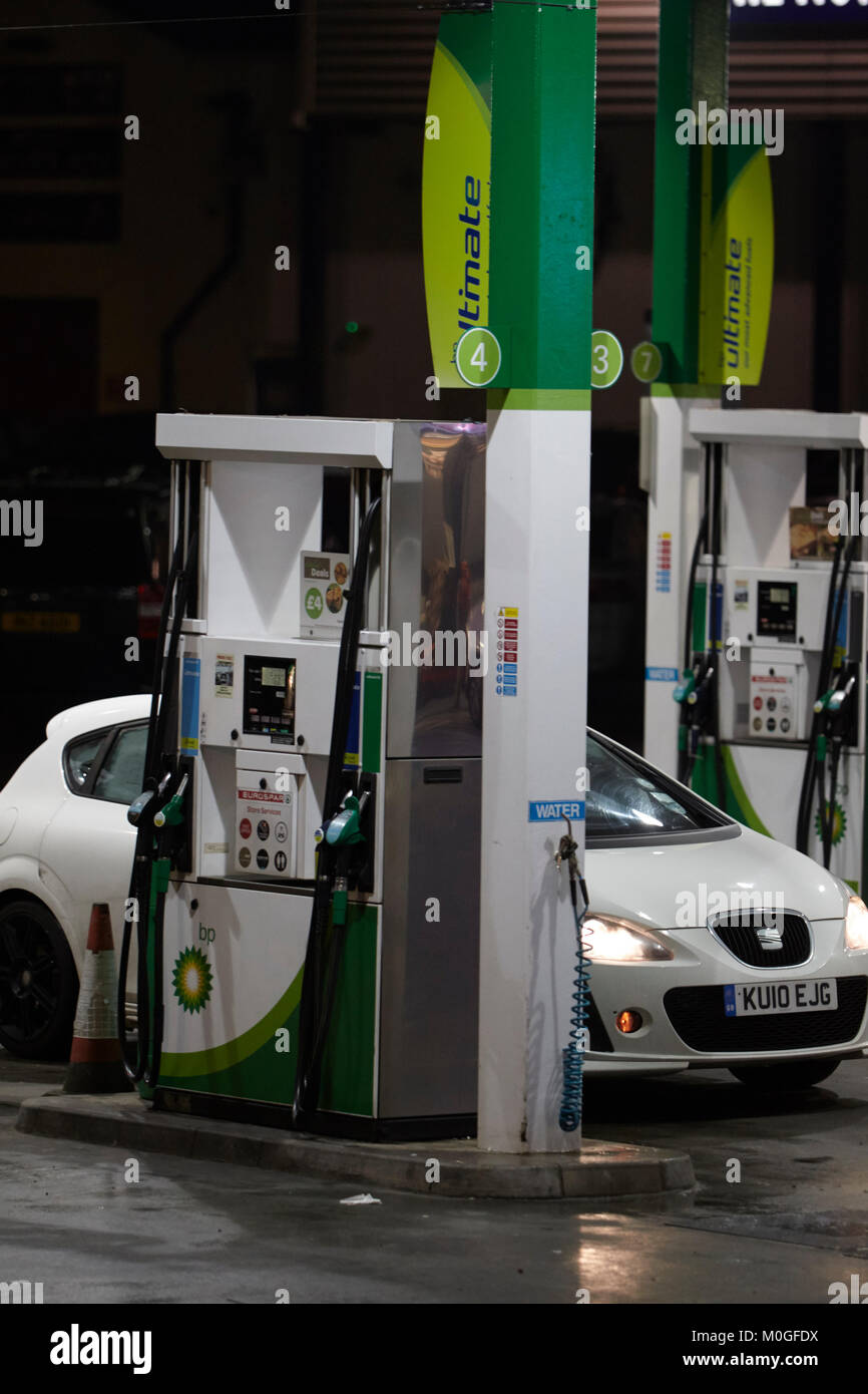 Il rifornimento di carburante per auto al garage BP e il piazzale antistante automatica con le pompe di benzina di notte nel Regno Unito Foto Stock