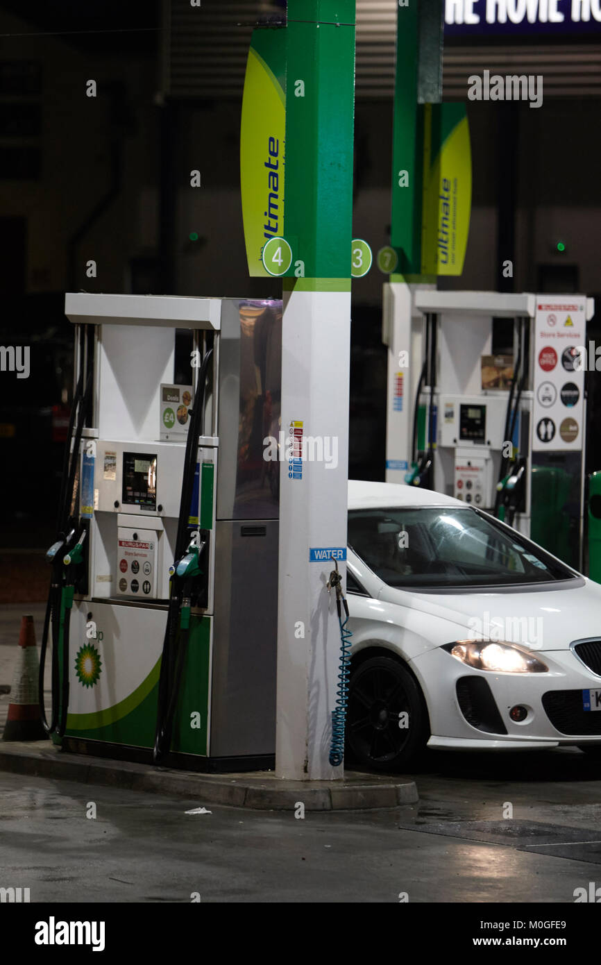 Il rifornimento di carburante per auto al garage BP e il piazzale antistante automatica con le pompe di benzina di notte nel Regno Unito Foto Stock