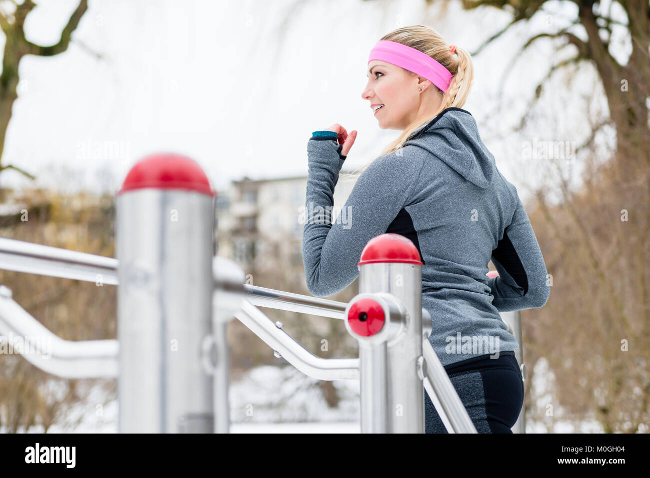 Giovane donna formazione delle sue gambe sul percorso fitness sul giorno di inverno Foto Stock