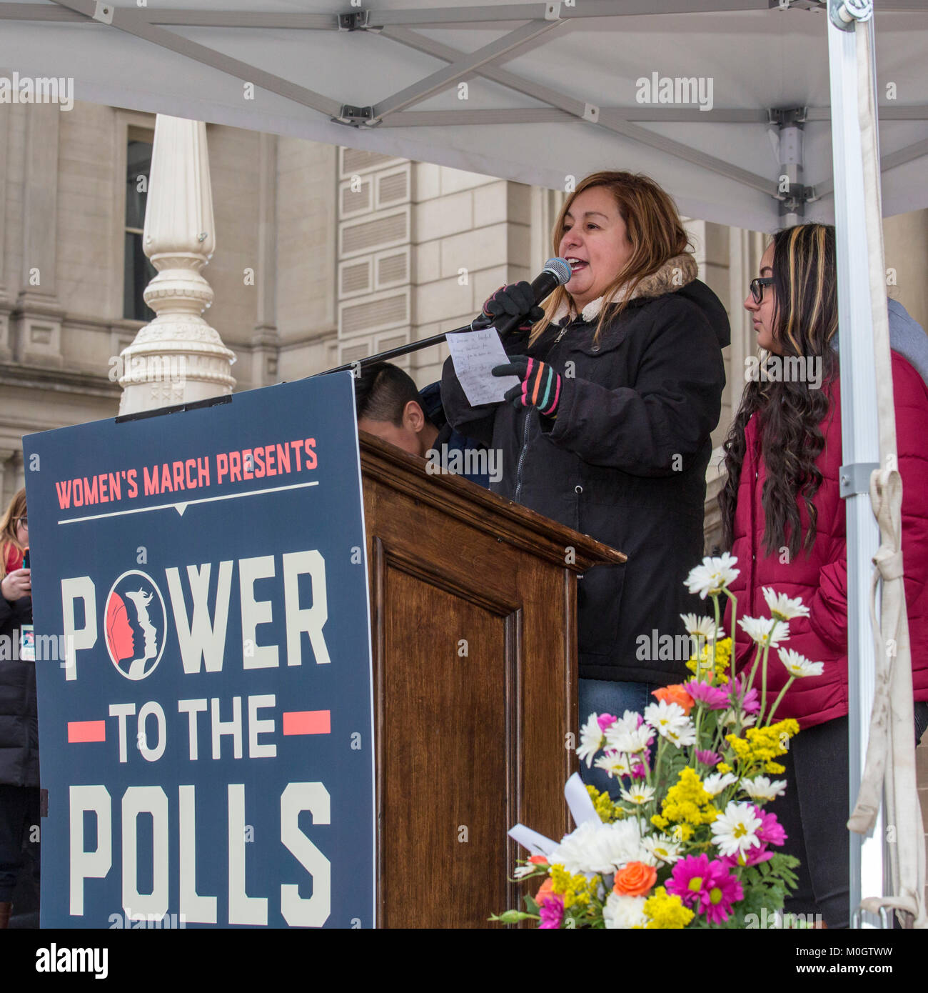 Lansing, Michigan STATI UNITI D'America - 21 Gennaio 2018 - Il primo anniversario delle donne del marzo a Washington che aveva protestato per l inaugurazione del presidente Donald Trump, le donne hanno marciato in diverse città in tutto il paese per incoraggiare le donne a votare per le alternative nelle 2018 elezioni di mid-term. Cindy Garcia, il cui marito Jorge Garcia era stato deportato in Messico fino a pochi giorni prima dopo aver vissuto negli Stati Uniti per quasi 30 anni, ha parlato a Lansing rally. Il giovane i bambini erano con lei: Solieil, 15 (a destra) e Jorge Jr., 12 (visibile parzialmente). Cindy Garcia è un membro della United Auto lavoratori 600 locali. La Cre Foto Stock