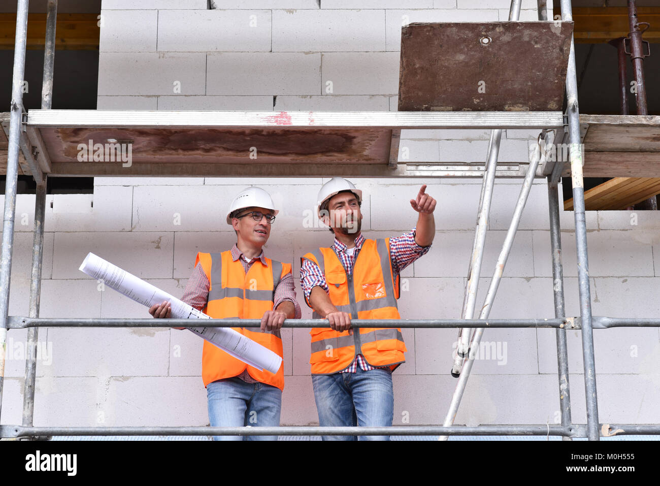 Il lavoro di squadra sul sito in costruzione - site manager e architetto sul sito durante la costruzione di una casa Foto Stock