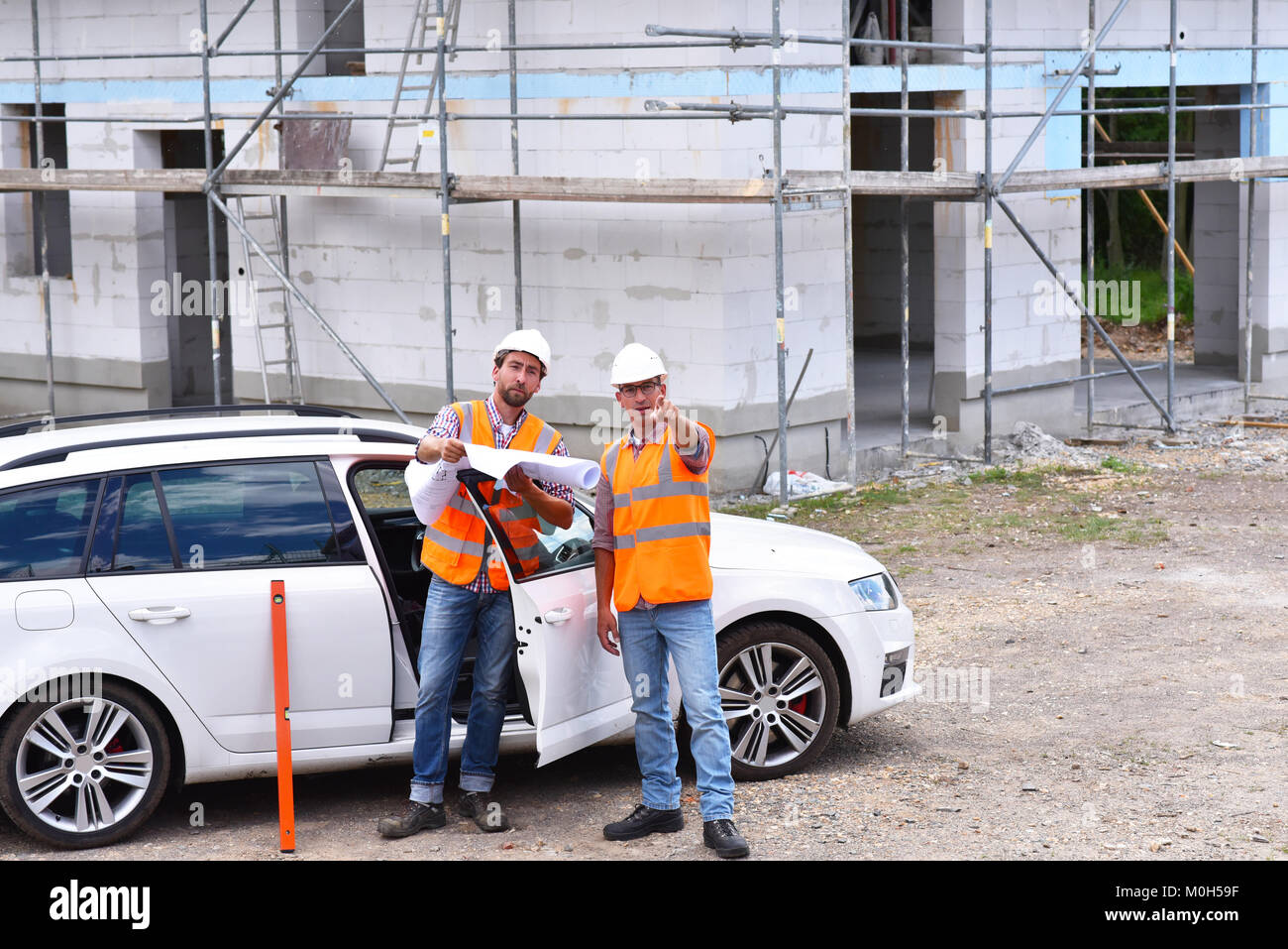 Il lavoro di squadra sul sito in costruzione - site manager e architetto sul sito durante la costruzione di una casa Foto Stock