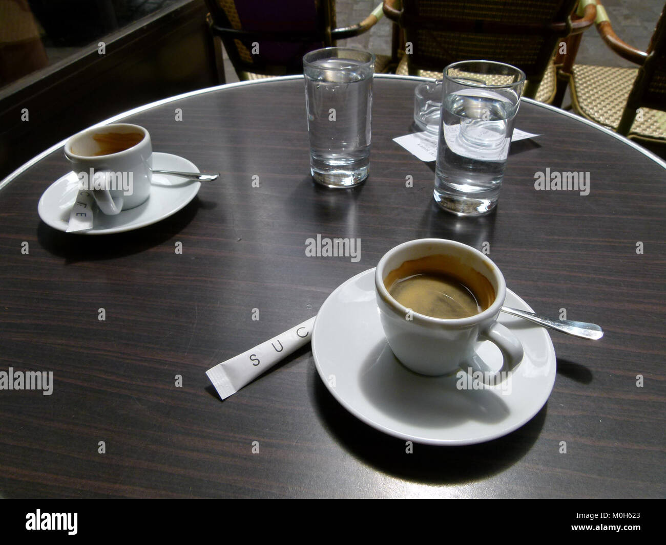 Questa immagine raffigura una terrazza all'aperto con tavoli, posti a sedere e clienti che si godono cibo e bevande in un ambiente urbano pubblico. Foto Stock
