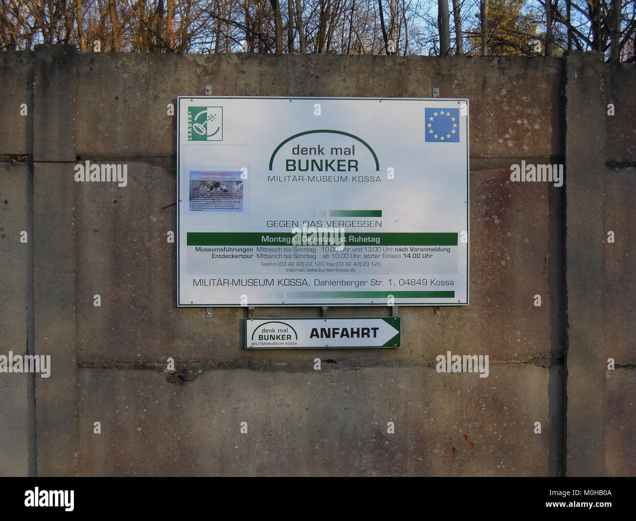 Un cartello al Bunker Kossa mostra informazioni sugli orari di apertura del museo militare, che riflettono il valore storico ed educativo del sito. Foto Stock
