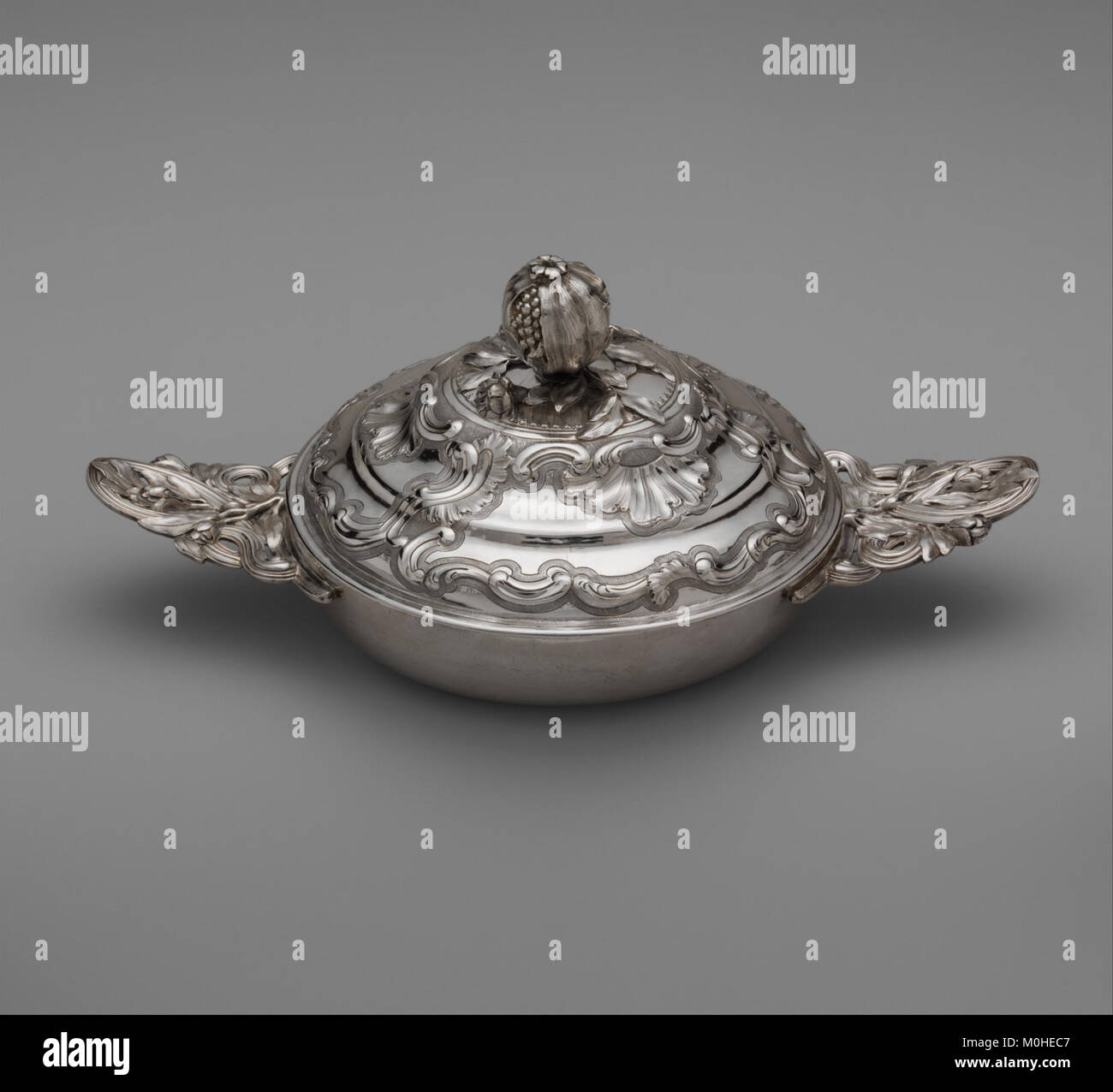 L'oggetto è una ciotola decorativa coperta, realizzata in ceramica o metallo, con un coperchio a cupola montato su una ciotola poco profonda. La nave è ornata da vetrate, goffrature o motivi incisi e può essere stata utilizzata come contenitore di cibo o come pezzo da servire per uso domestico o cerimoniale. Foto Stock