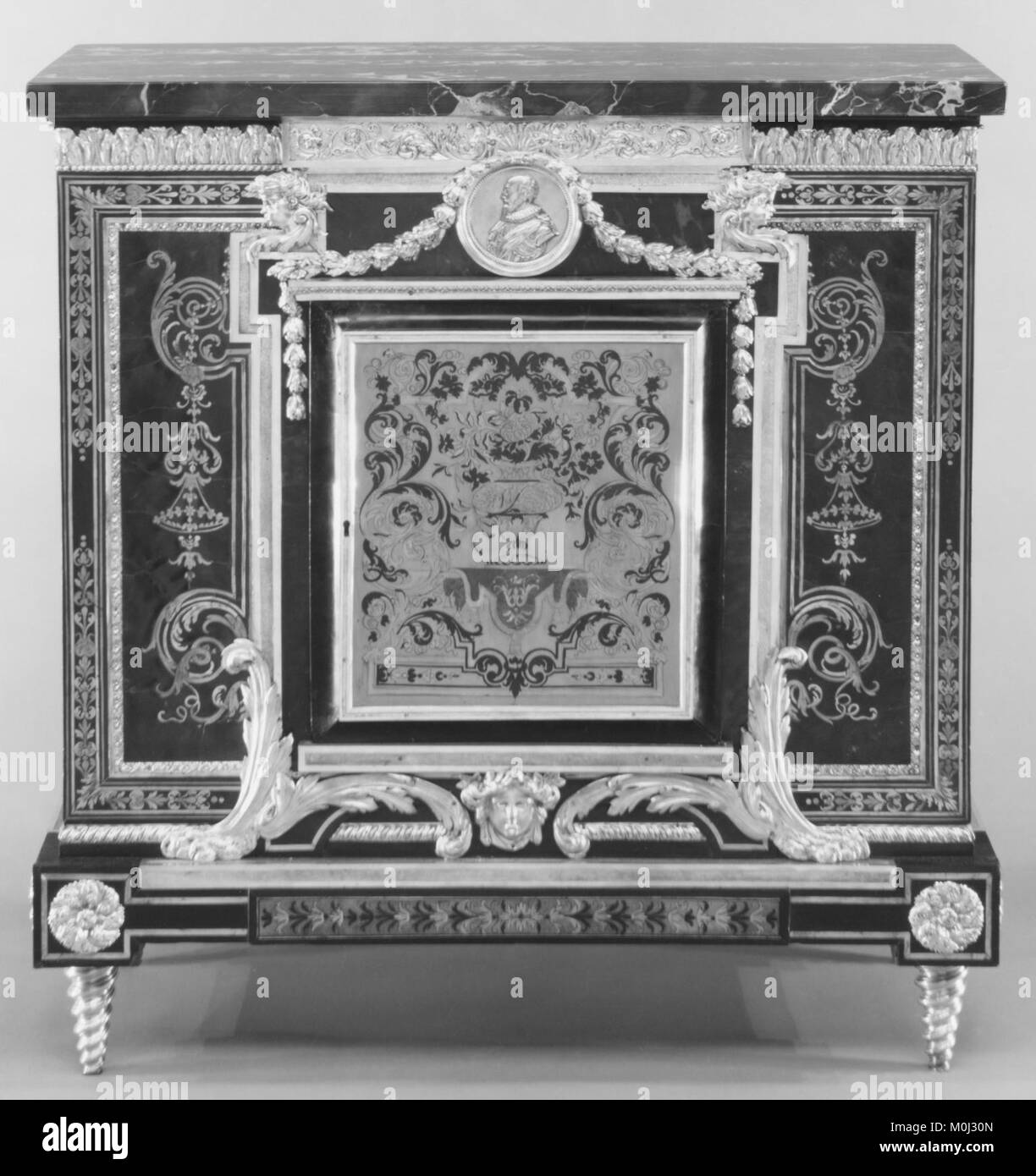 Un armadietto basso, uno di una coppia, del Metropolitan Museum of Art, che esemplifica l'artigianato francese del XVIII secolo. Il pezzo è caratterizzato da lavorazioni ornamentali in legno e intarsio decorativo, che riflettono il design di mobili di lusso dell'epoca. Foto Stock