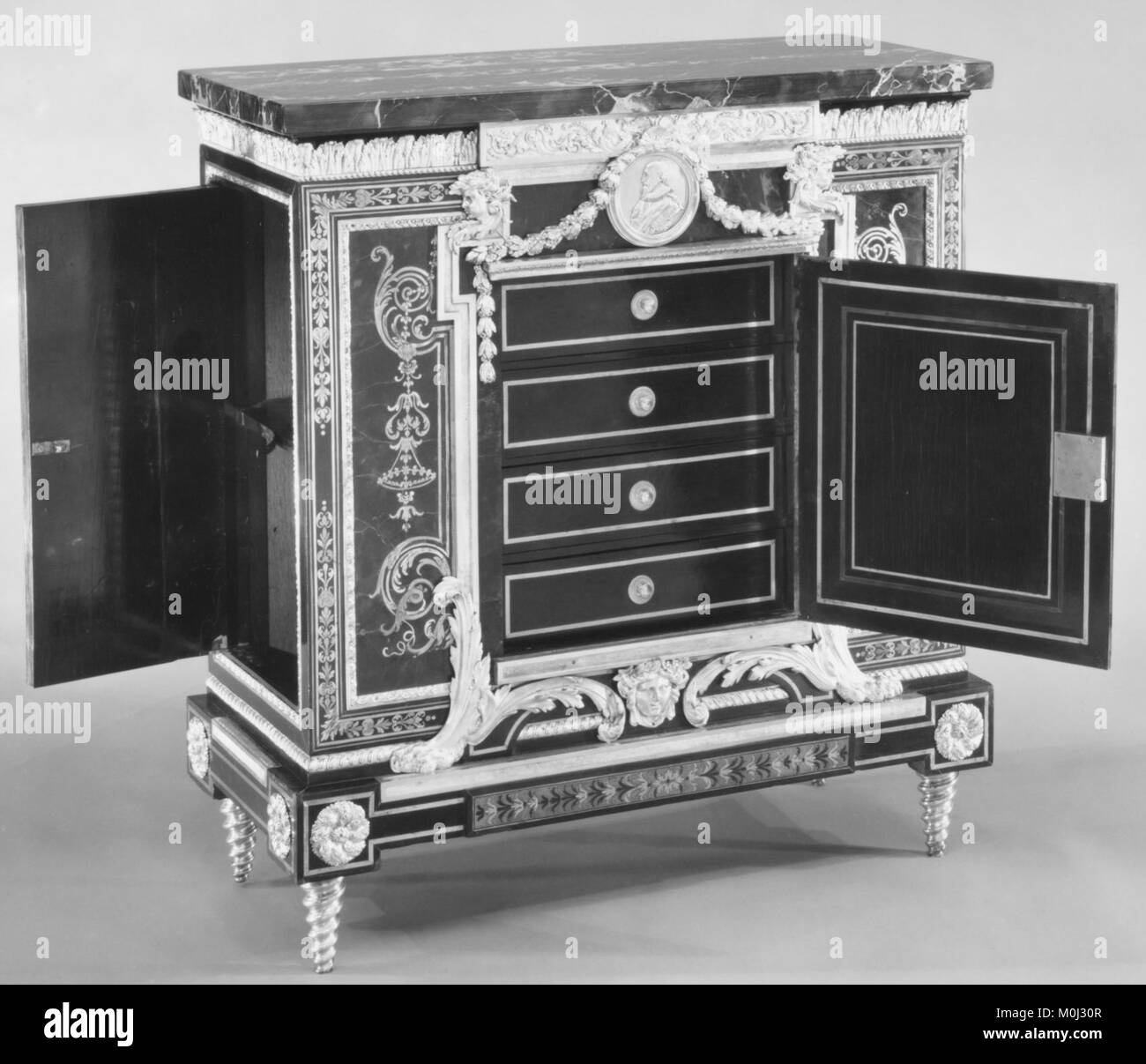 Questo armadietto basso francese della fine del XVIII secolo, uno di una coppia su disegno di André Charles Boulle, è impiallacciato con ebano ed è caratterizzato da guscio di tartaruga, ottone e intarsio in peltro, supporti in bronzo dorato e un piano in marmo Portor, a dimostrazione dell'influenza duratura dell'intarsio Boulle nel periodo. Foto Stock