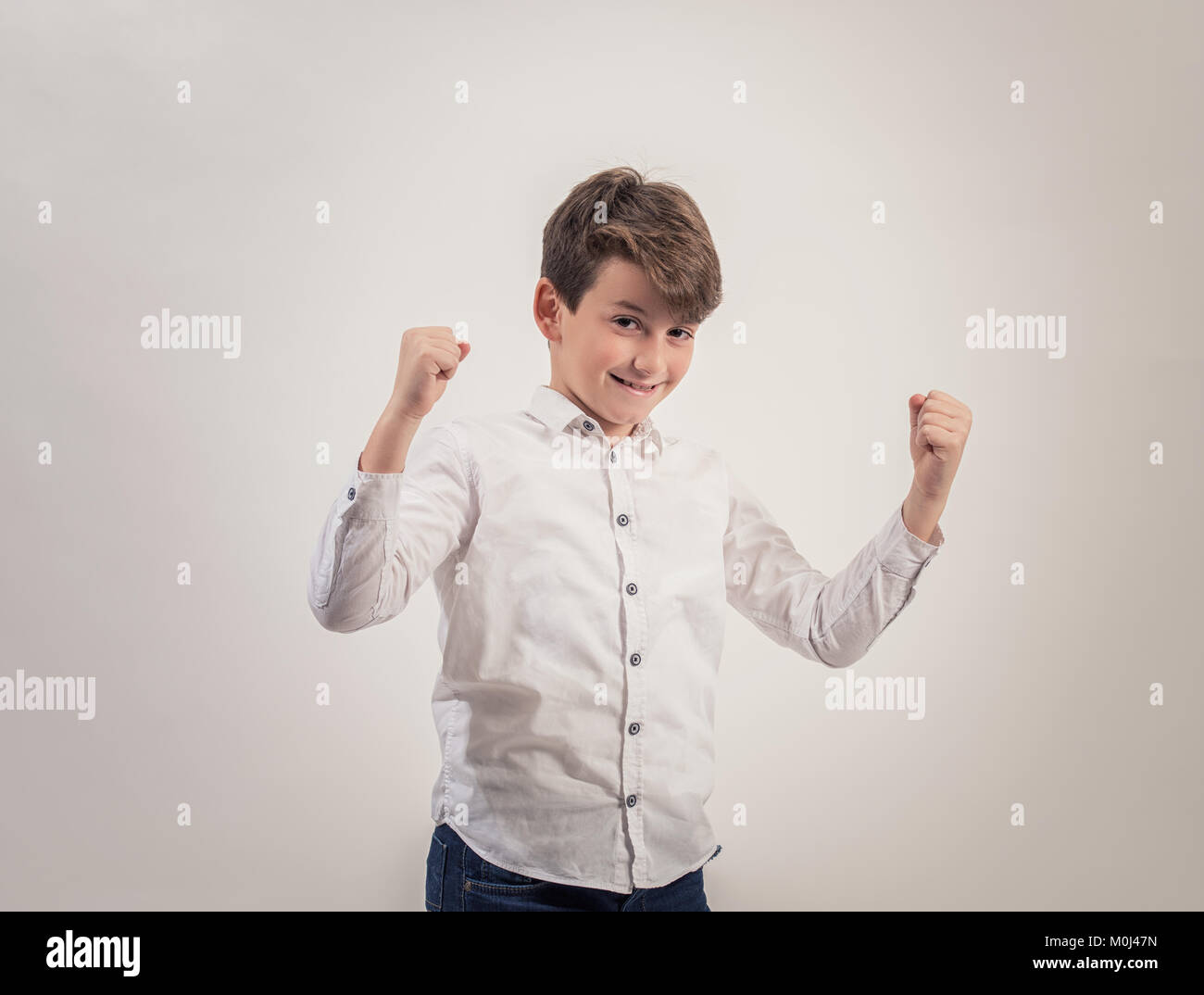 Ritratto di ragazzo caucasico su sfondo grigio,forti e fieri. Foto Stock