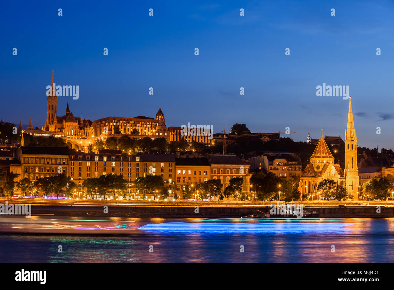 Città di Budapest di notte, crociera barche sentieri di luce sul fiume Danubio, skyline del lato di Buda, Ungheria. Foto Stock