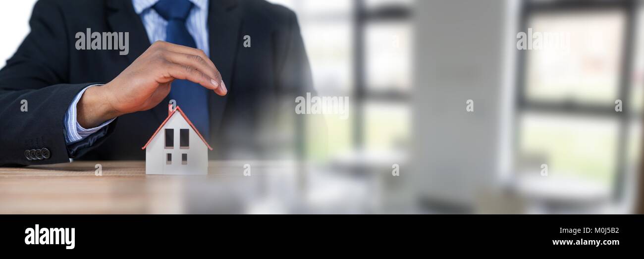 Modello di casa sotto imprenditore il Mani protettrici Foto Stock