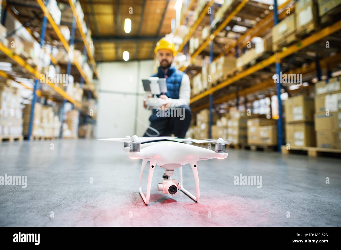 Uomo con drone in un magazzino. Foto Stock
