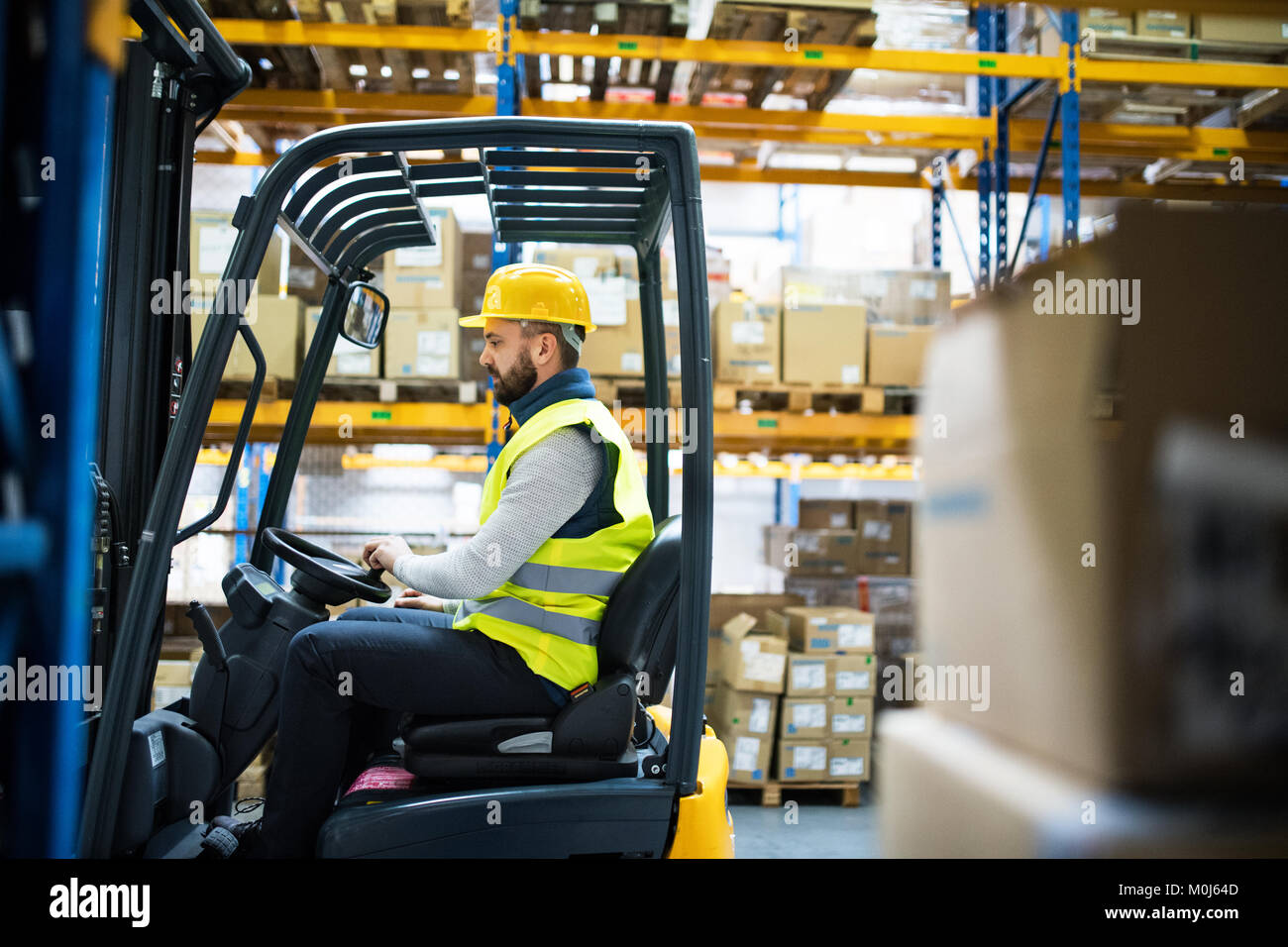 Magazziniere lavoratore con un carrello elevatore. Foto Stock