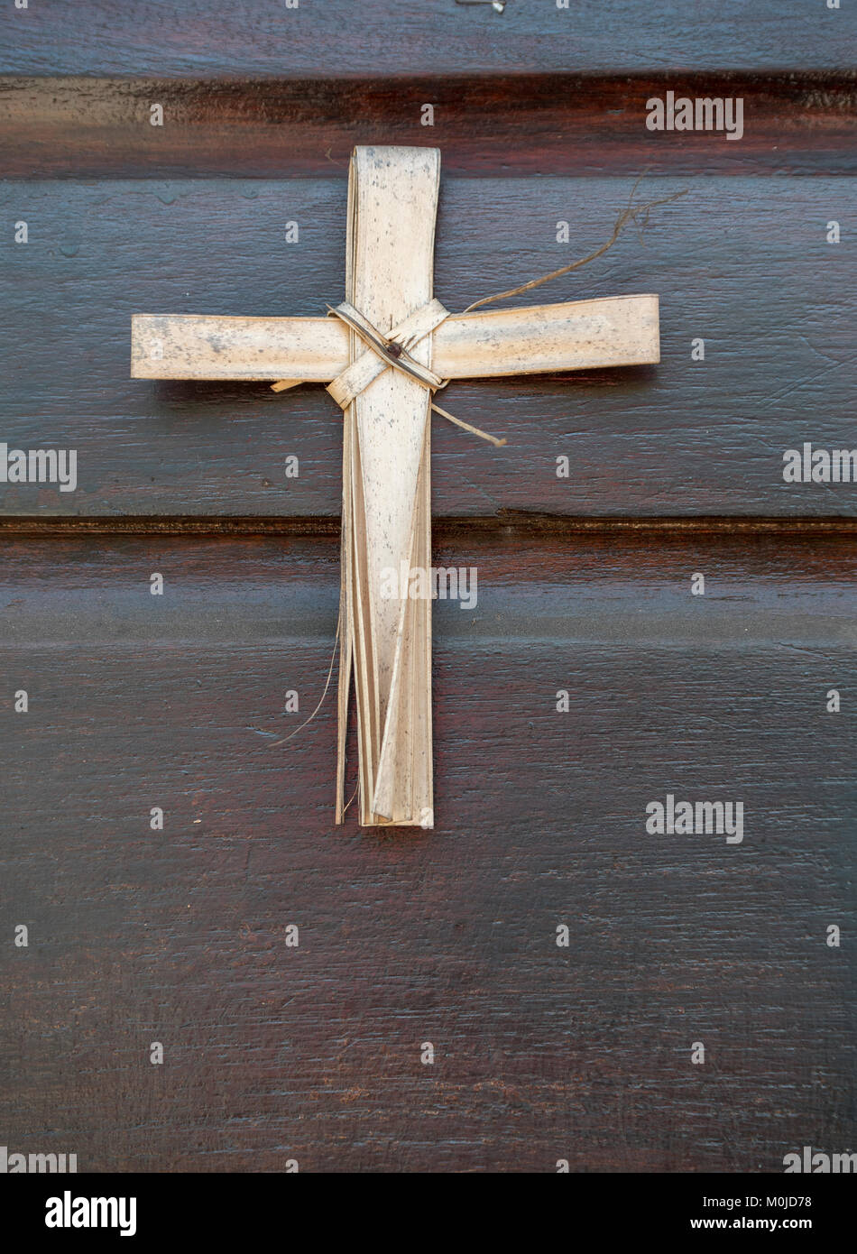 Una semplice croce religiosa su un case porta anteriore realizzato da foglie di palma domenica delle Palme, in Puerto Corinto Nicaragua america centrale Foto Stock