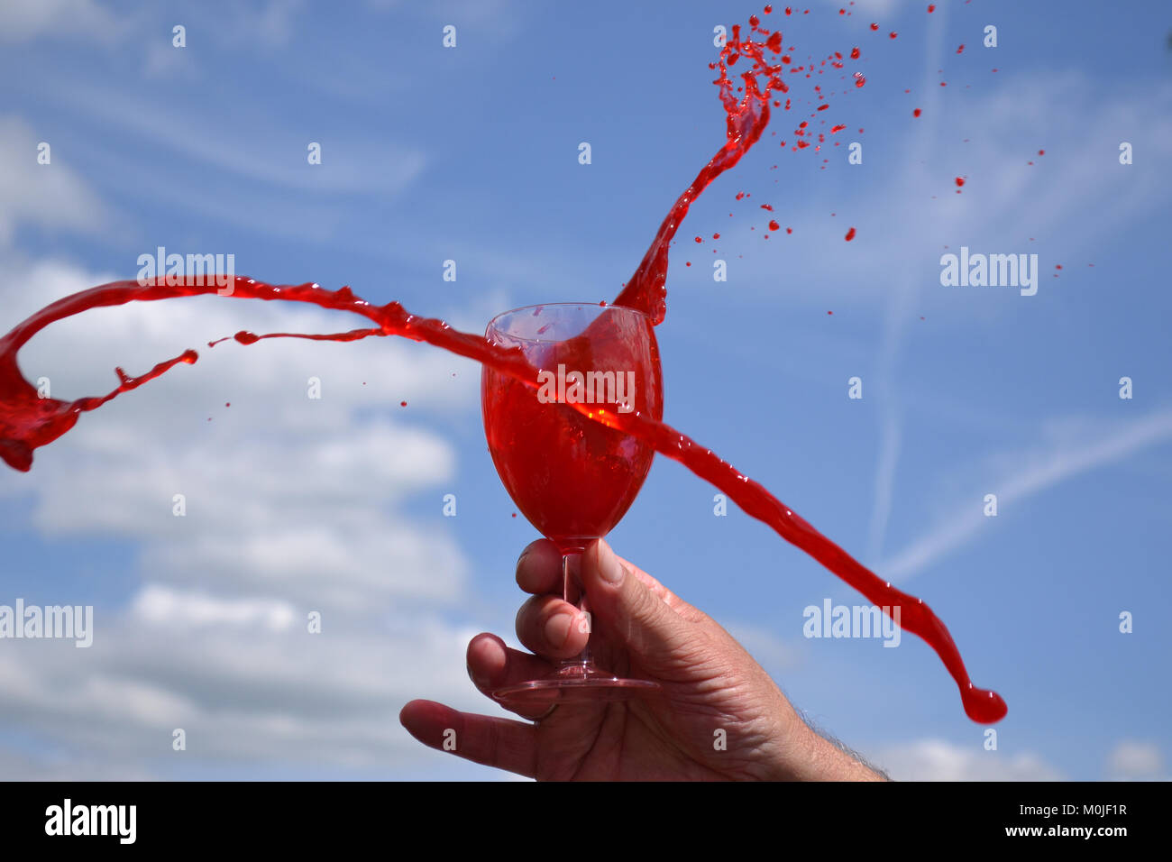 Vino rosso vetro contro il cielo blu Foto Stock
