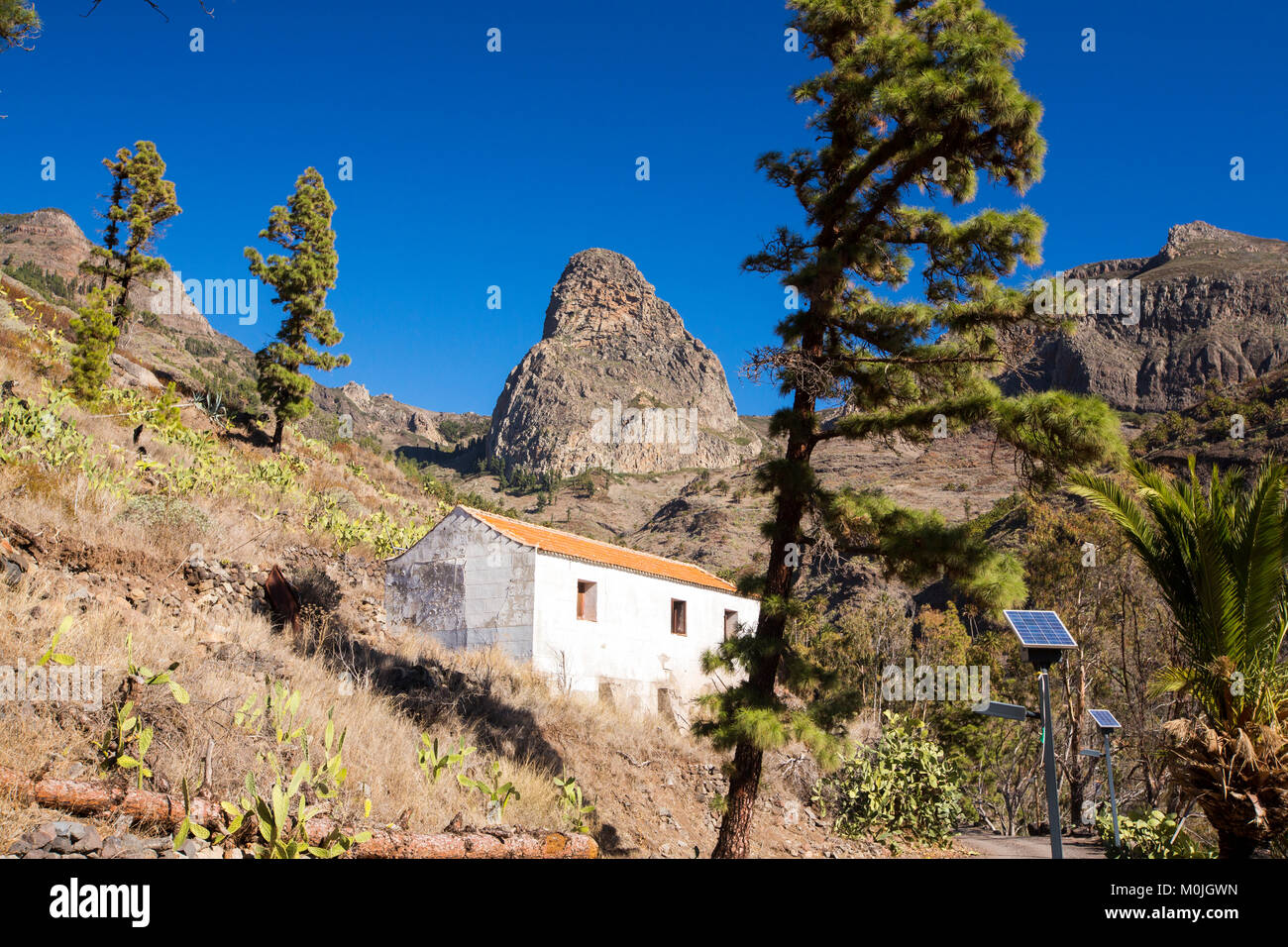 La Gomera paesaggio in Benchijigua, Isole Canarie, guardando verso il classico Roque de Agando con energia solare lampade stradali. Foto Stock