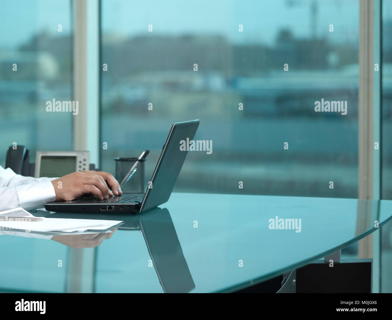 Arabia man mano la digitazione su computer portatile presso la sua scrivania. Foto Stock