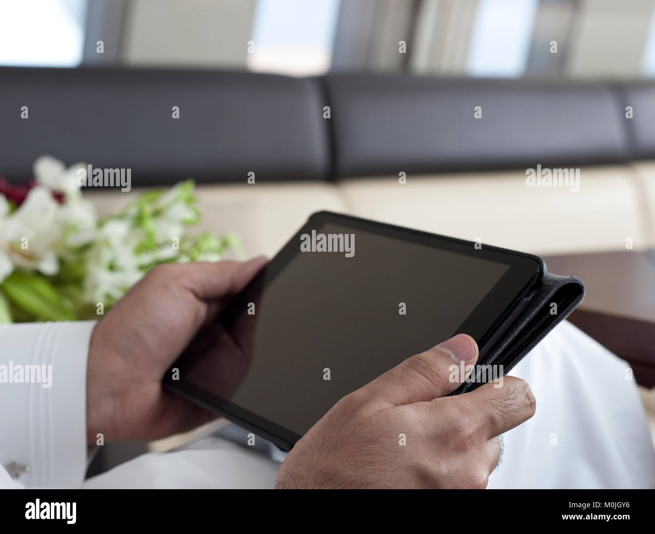 Saudi Arabian VIP Mani e utilizzo di tablet Foto Stock