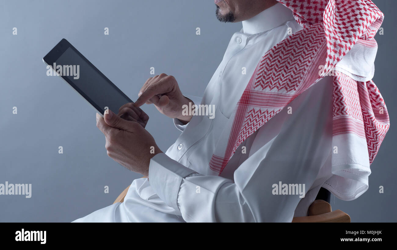 Saudi Arabian uomo Mani e utilizzo di tablet Foto Stock