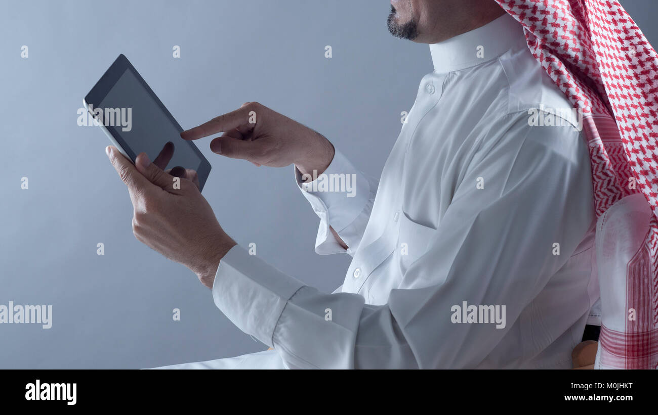 Saudi Arabian uomo Mani e utilizzo di tablet Foto Stock