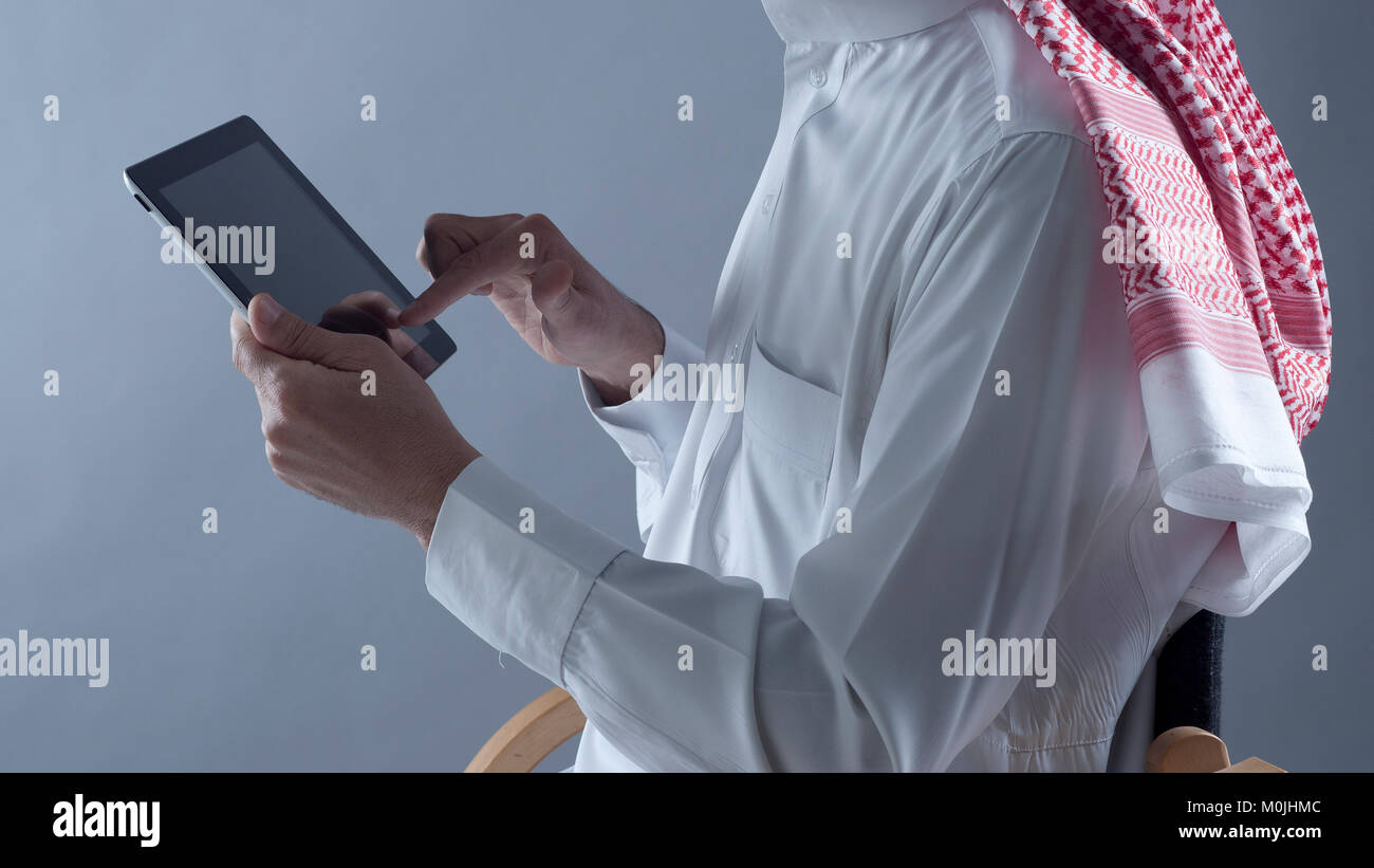 Saudi Arabian uomo Mani e utilizzo di tablet Foto Stock