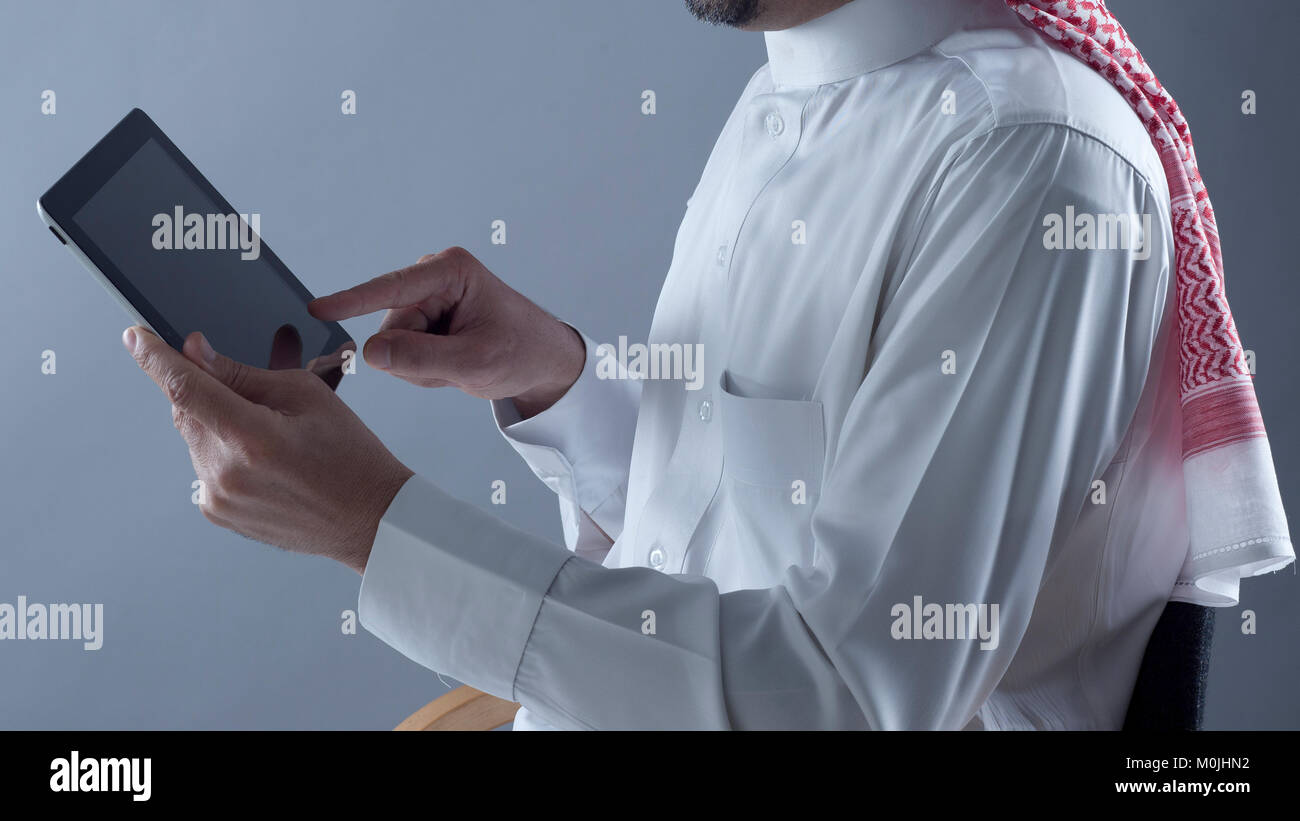 Saudi Arabian uomo Mani e utilizzo di tablet Foto Stock