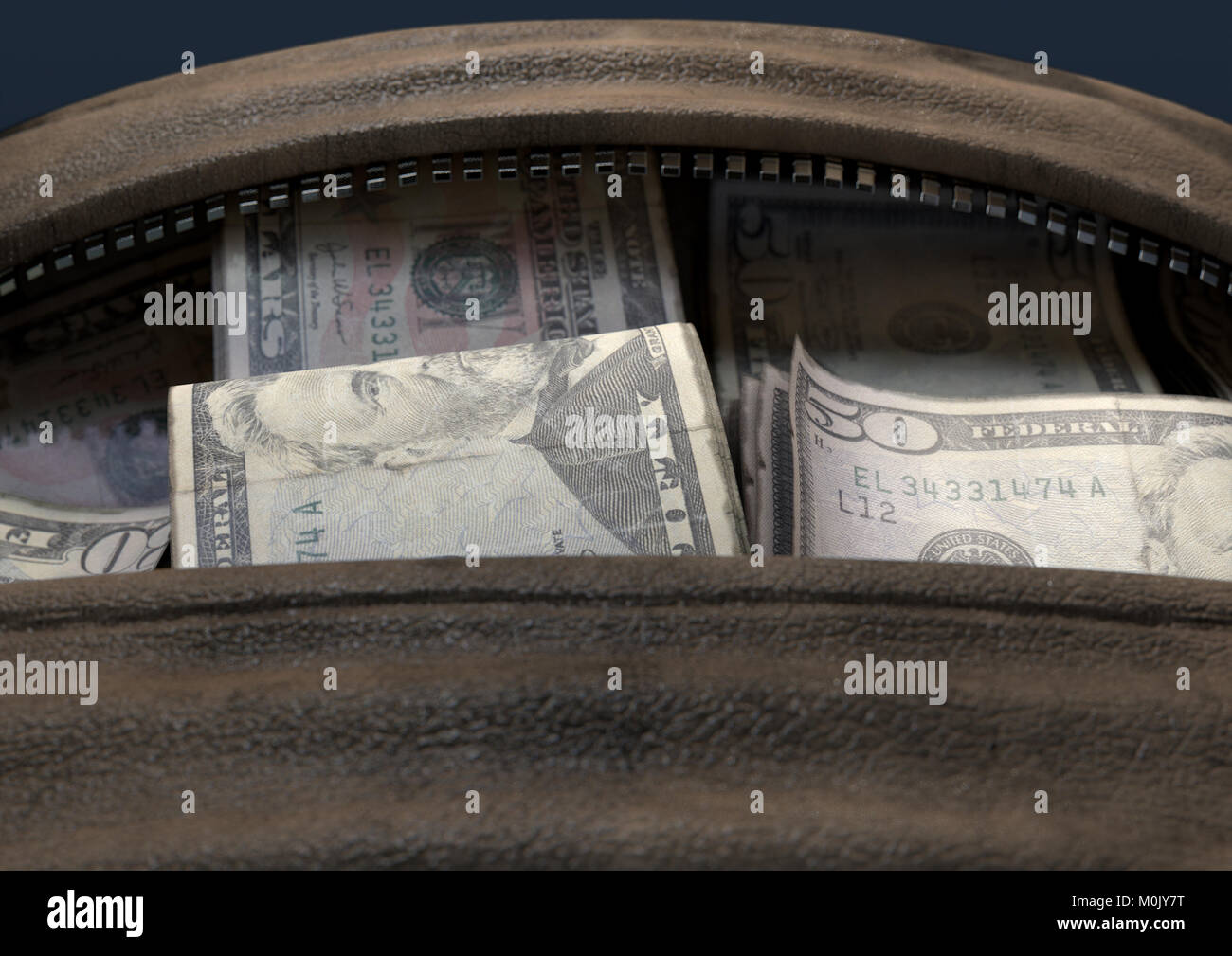 Un concetto che raffigura un aperto in pelle marrone borsone rivelando di fasci di laminati illecita US dollar note - 3D render Foto Stock