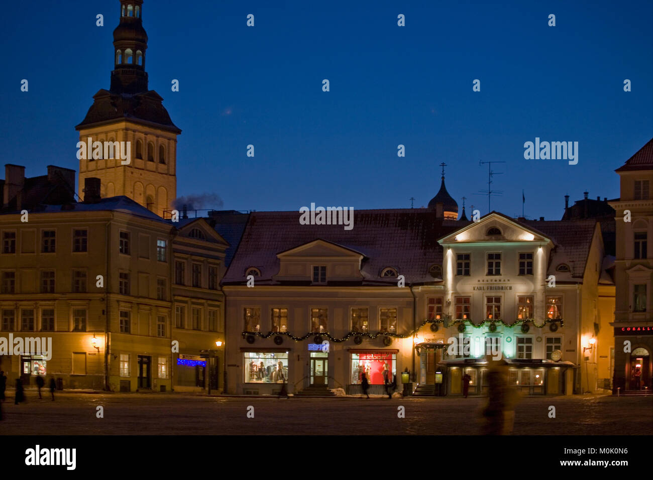 Raekoja Plats con la torre di Niguliste al di là di una sera d'inverno,: Tallinn, Estonia Foto Stock