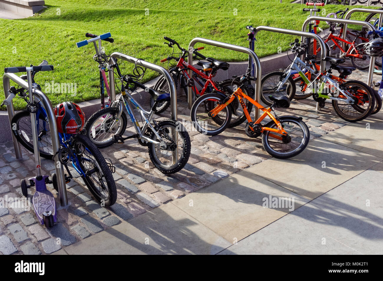 Biciclette per bambini al di fuori della scuola materna in London, England Regno Unito Regno Unito Foto Stock