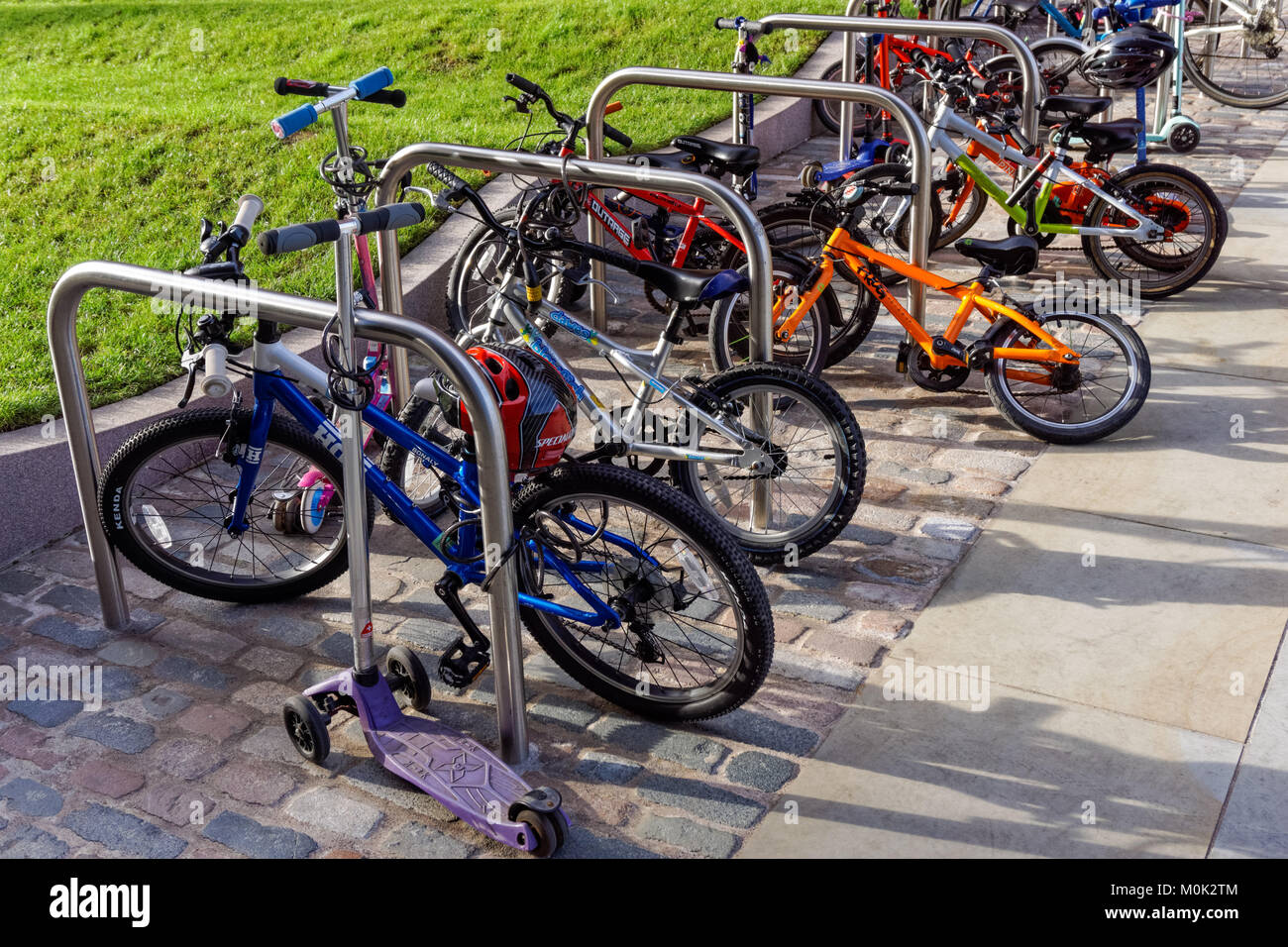 Biciclette per bambini al di fuori della scuola materna in London, England Regno Unito Regno Unito Foto Stock
