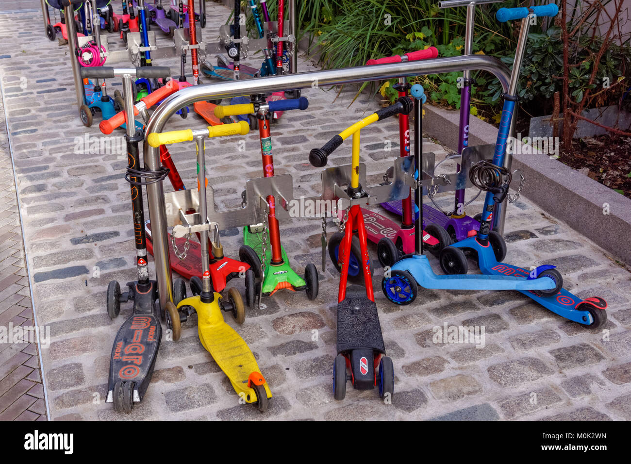 Kids scooters al di fuori della scuola materna in London, England Regno Unito Regno Unito Foto Stock