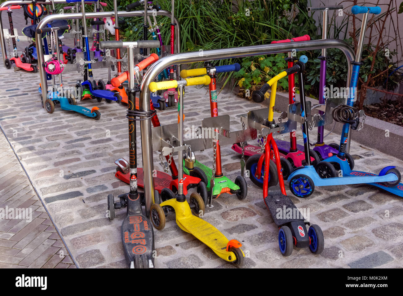 Kids scooters al di fuori della scuola materna in London, England Regno Unito Regno Unito Foto Stock