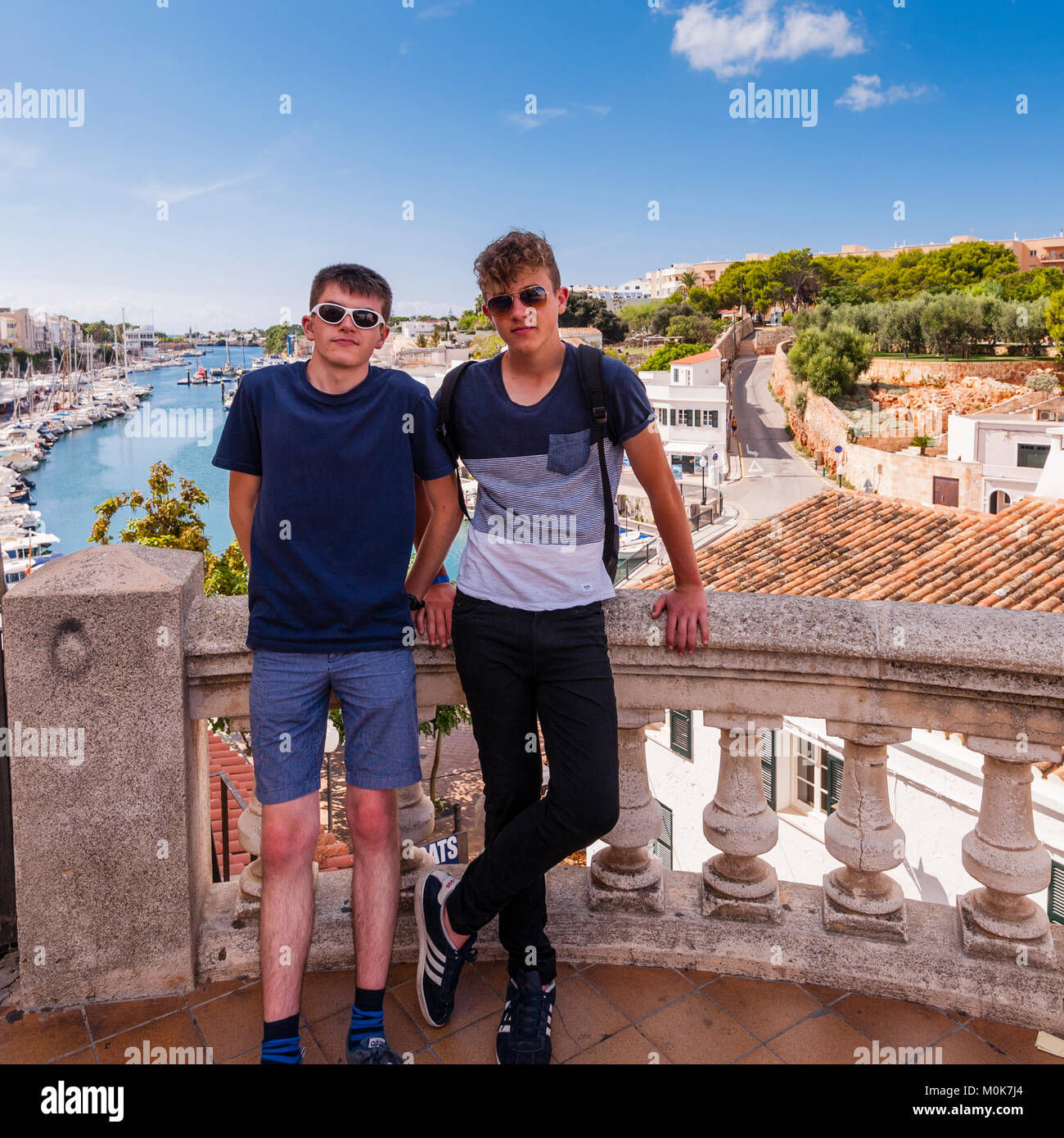 Due ragazzi adolescenti fratelli nel porto di Ciutadella de Menorca , Minorca , Isole Baleari , Spagna Foto Stock